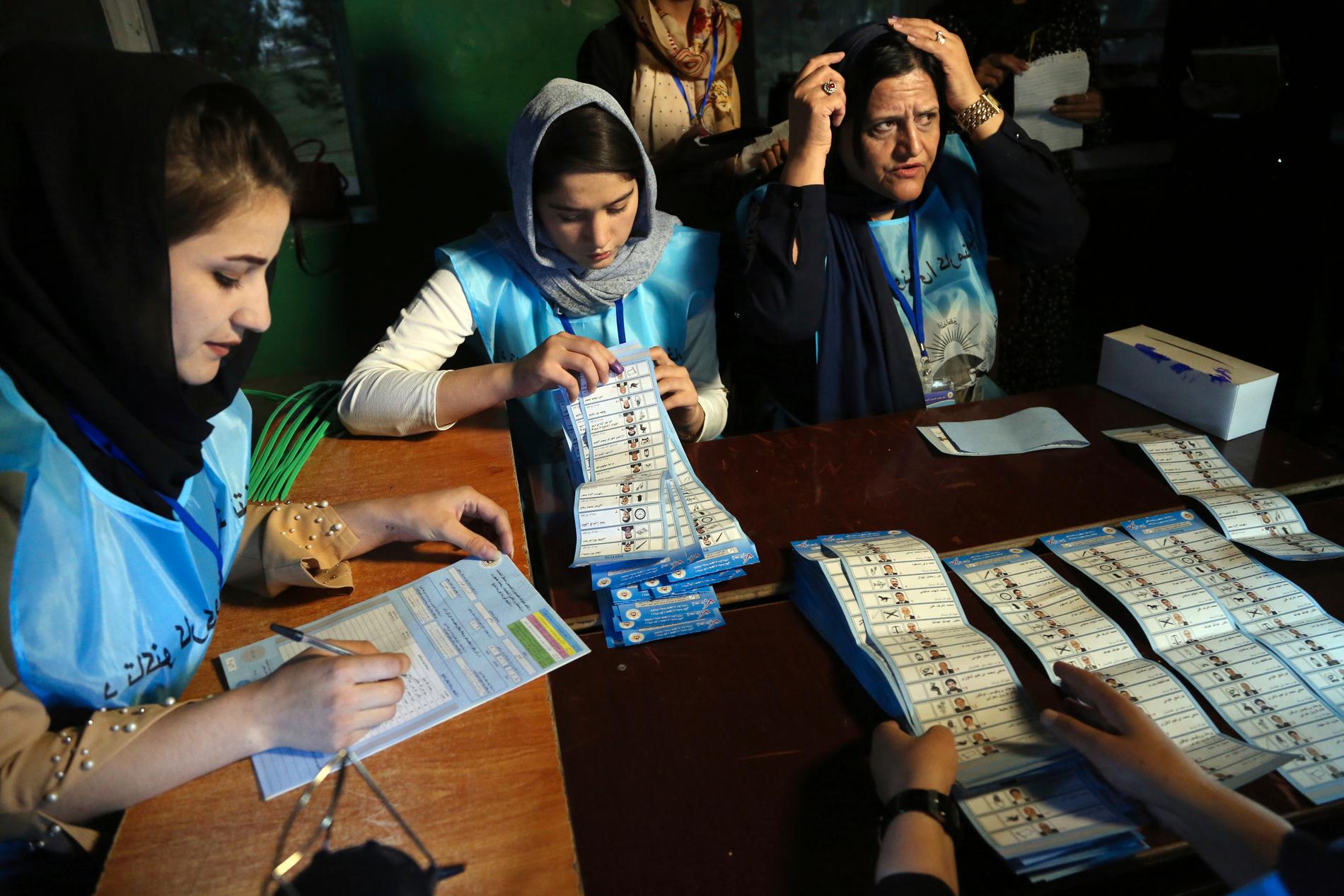 Afghanska valarbetare räknar röster under lördagens val.