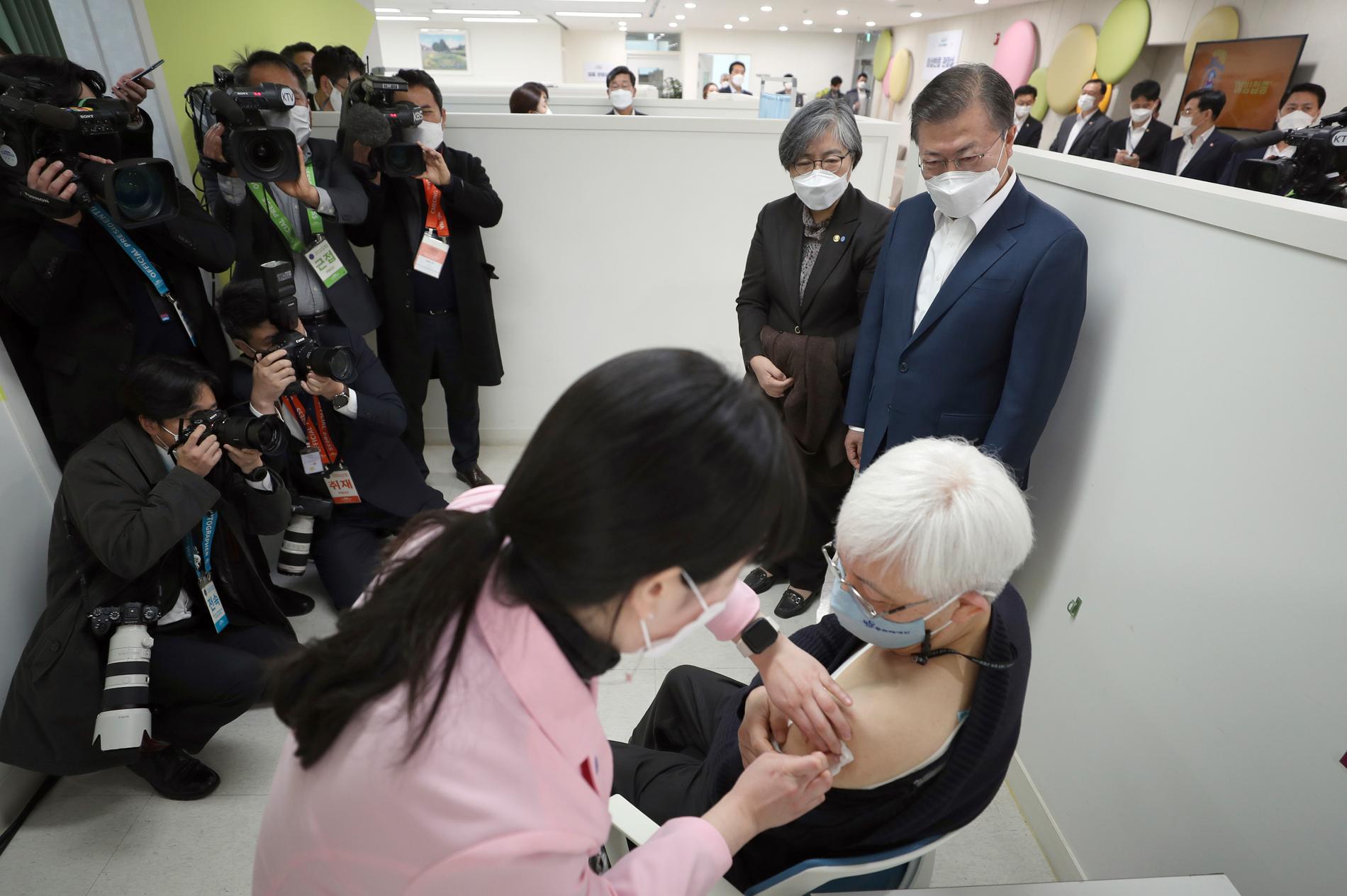 Sydkoreas president Moon Jae-In ser på när en läkare får sin första vaccindos.