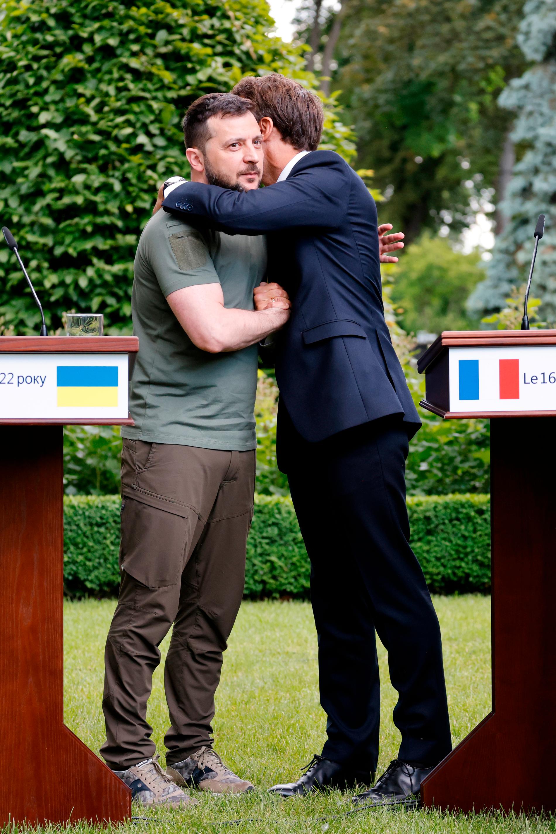 Ukrainas president Volodymyr Zelenskyj och franska presidenten Emmanuel Macron omfamnar varandra. 