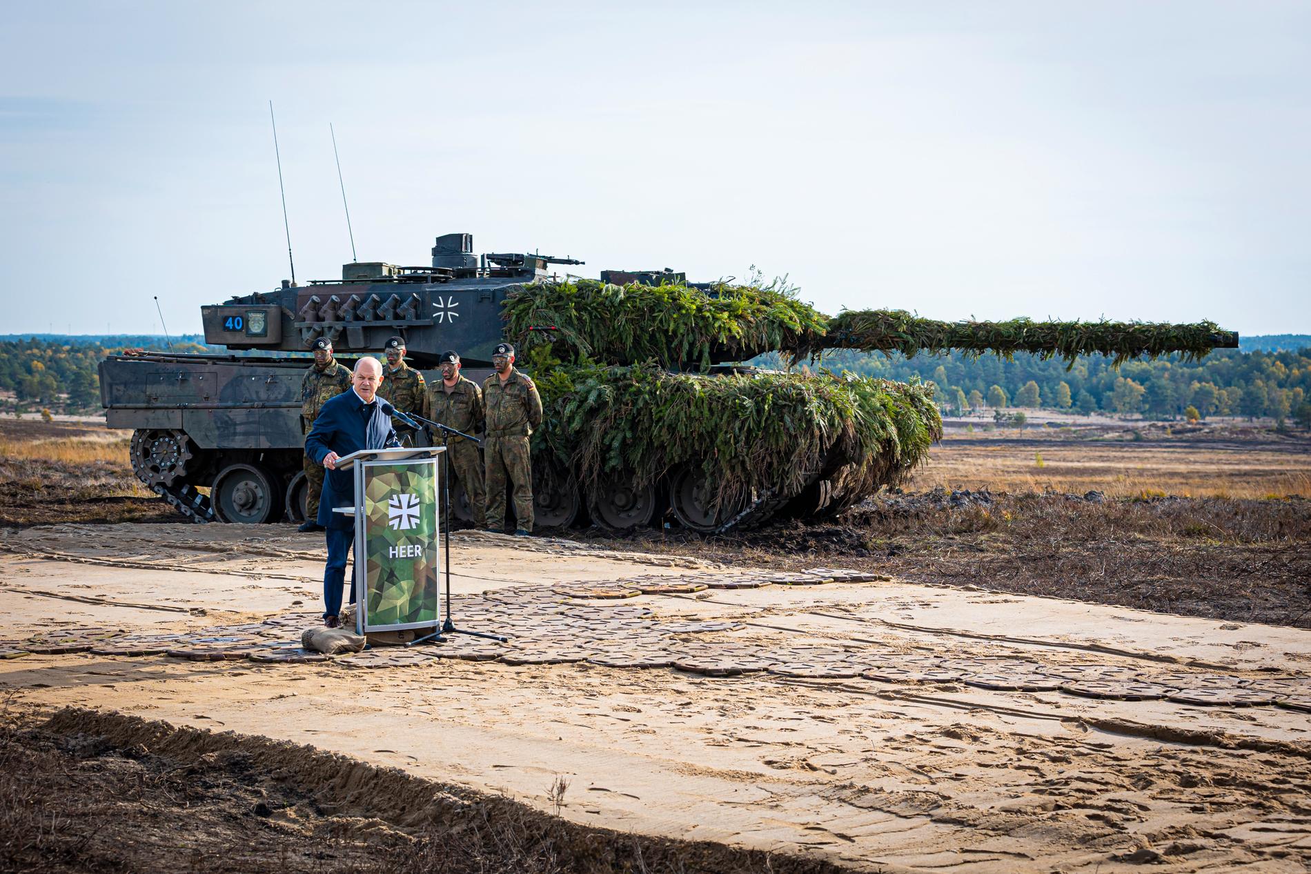 Tysklands förbundskansler Olaf Scholz  framför en Leopard 2 huvudstridsvagn. ev.