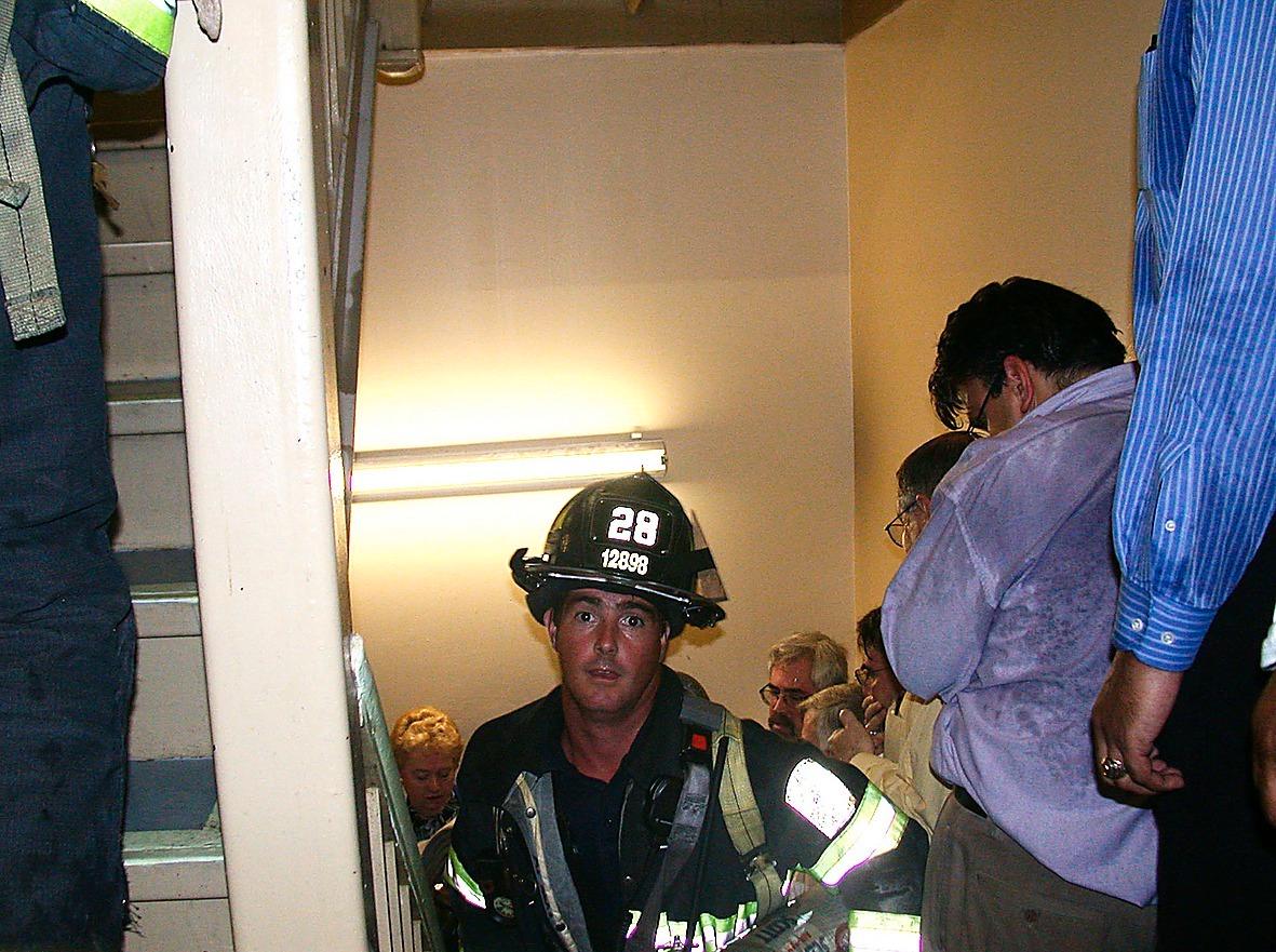 En brandman på väg upp i World Trade Center medan kontorsarbetarna försöker ta sig ut.
