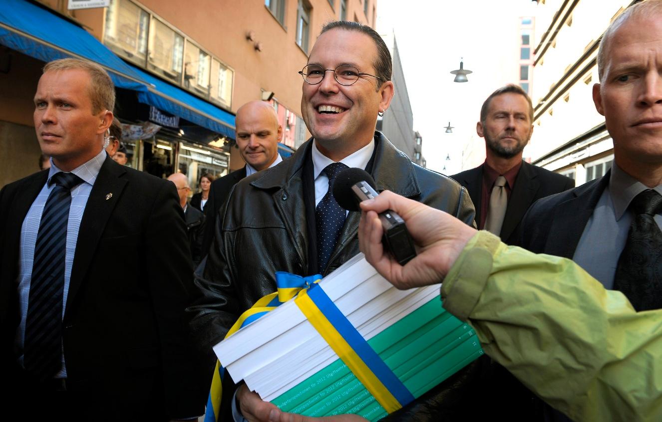 SNACKSALIG Finansminister Anders Borg (M) på väg mot riksdagen med höstbudgeten i en blågul rosett.