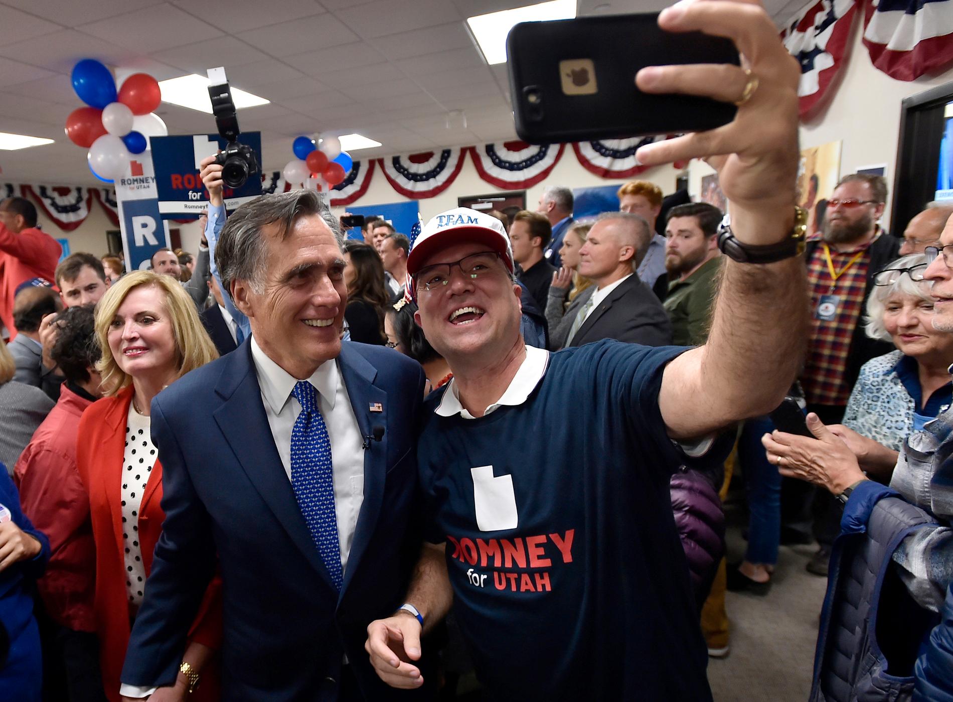 En glad Mitt Romney, som just valts till republikansk senator för Utah, poserar med en anhängare.