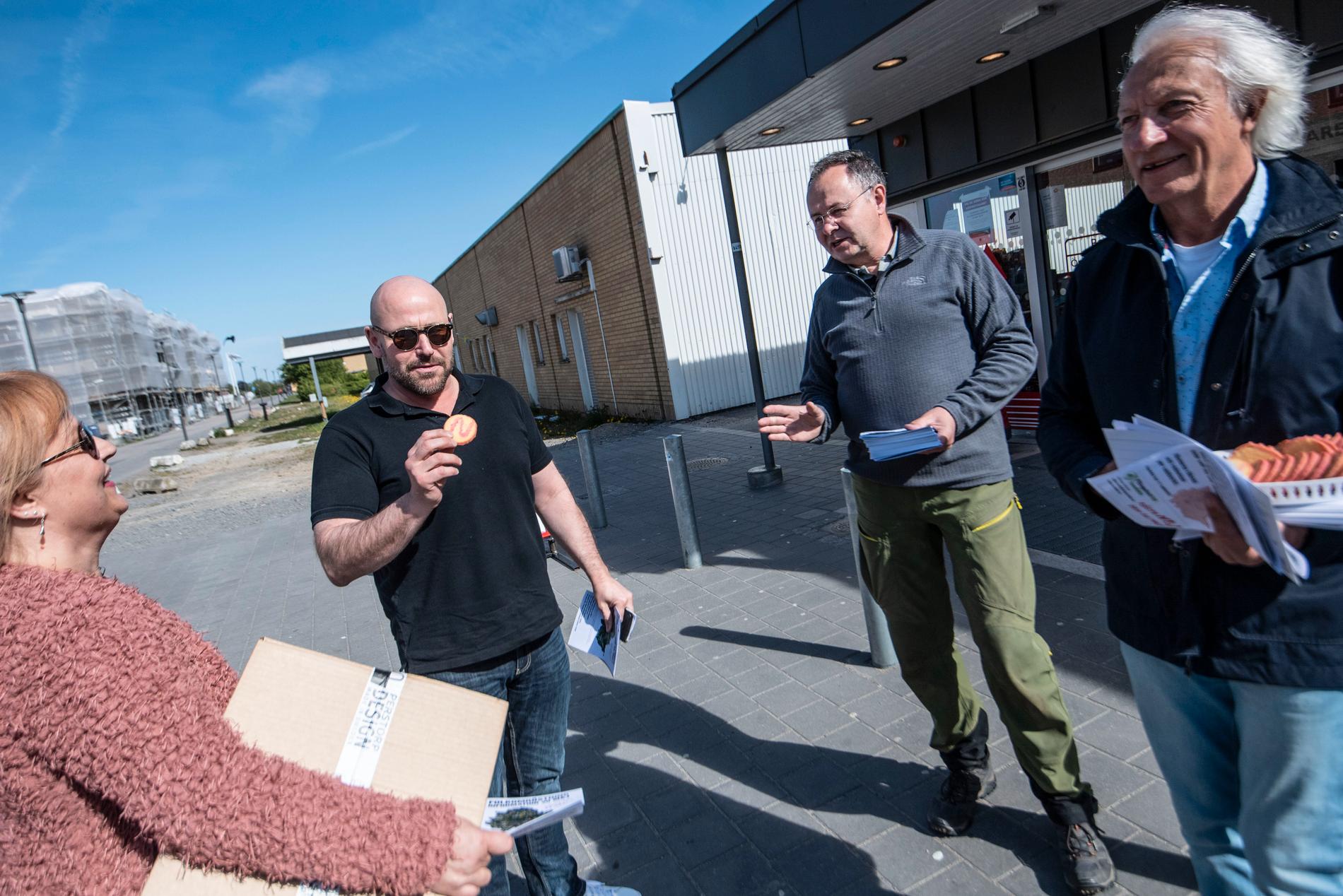 Therese Jacobsen Ljung stannar till och Dennis Sandström tar en "nejkaka" då ordföranden i partiet Älska Svedala, Mats Bentmar (2:a fr h), delar ut material och Bertil Lindberg (t h), föreningen Fängelsefritt Svedala, bjuder på "nejkakor" utanför Bara centrum i Svedala kommun.