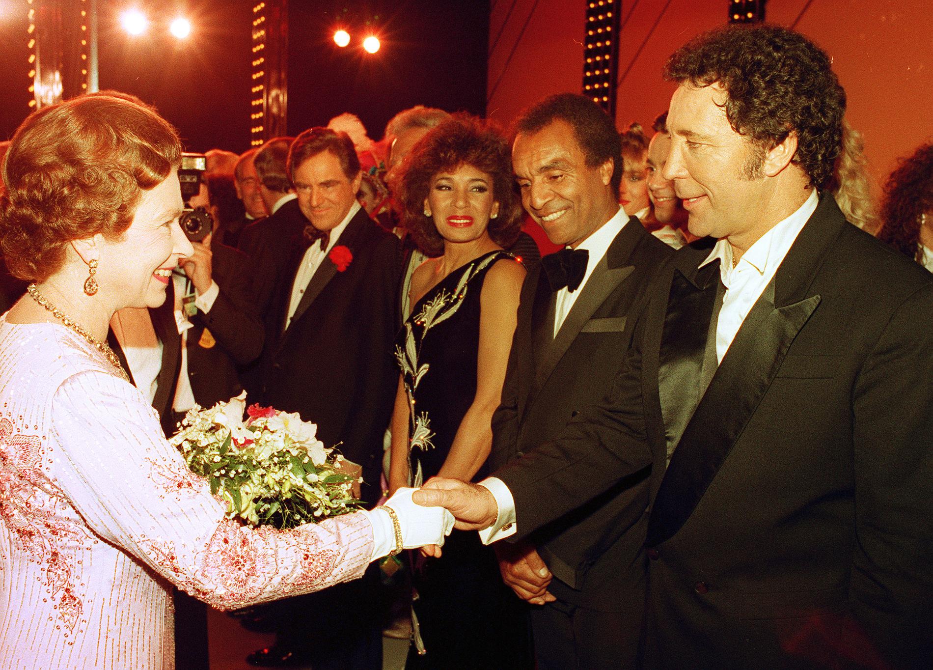 Kenny Lynch tillsammans med sångaren Tom Jones och sångerskan Shirley Bassey när de skakar hand med drottningen Elisabeth den andra.