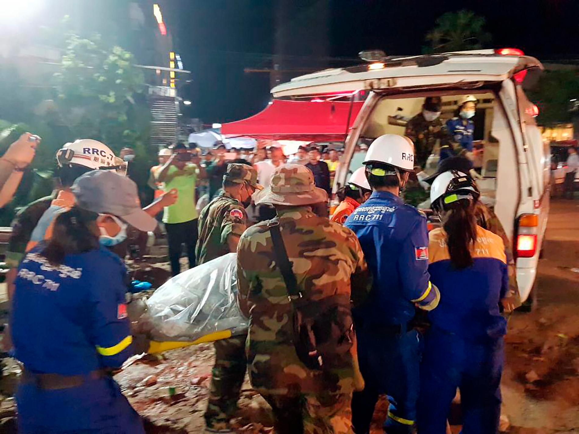 Räddningsarbetare lyfter in ett av offren i en ambulans.