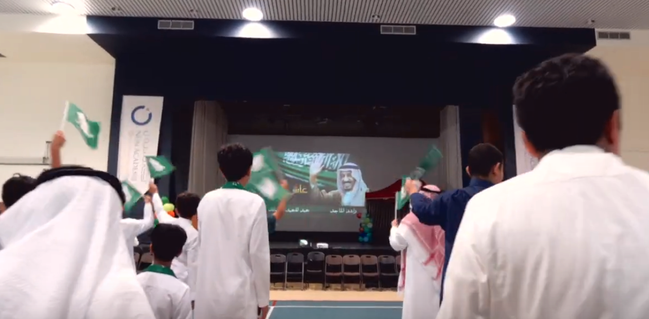 På Nün Academys Youtubekanal ser man hur elever viftar med flaggor för att hylla Saudiarabiens diktator. Svenska Saab och Kunskapsskolan ligger bakom skolan. 