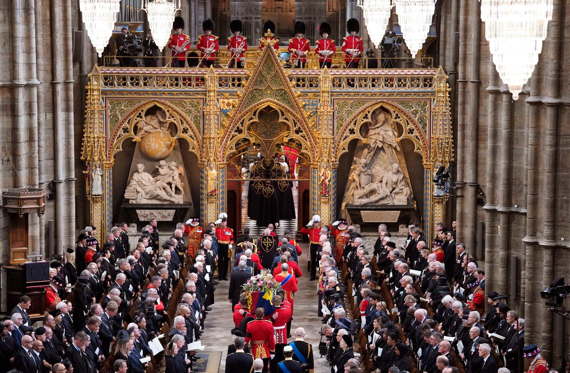 Kung Charles går bakom kistan när den förs ut från Westminster Abbey efter begravningen.