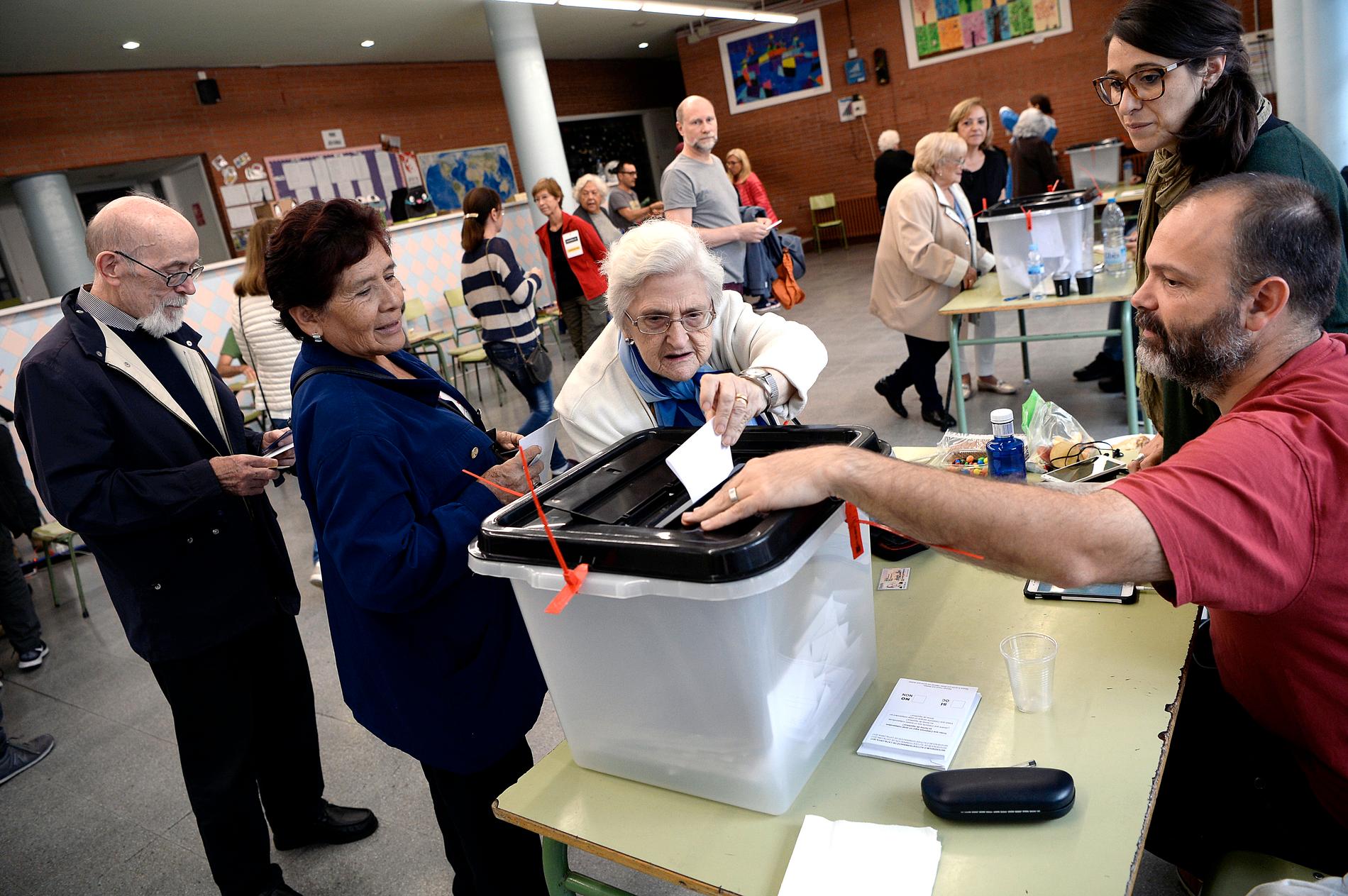 En kvinna lägger sin valsedel i en vallokal i Barcelona.