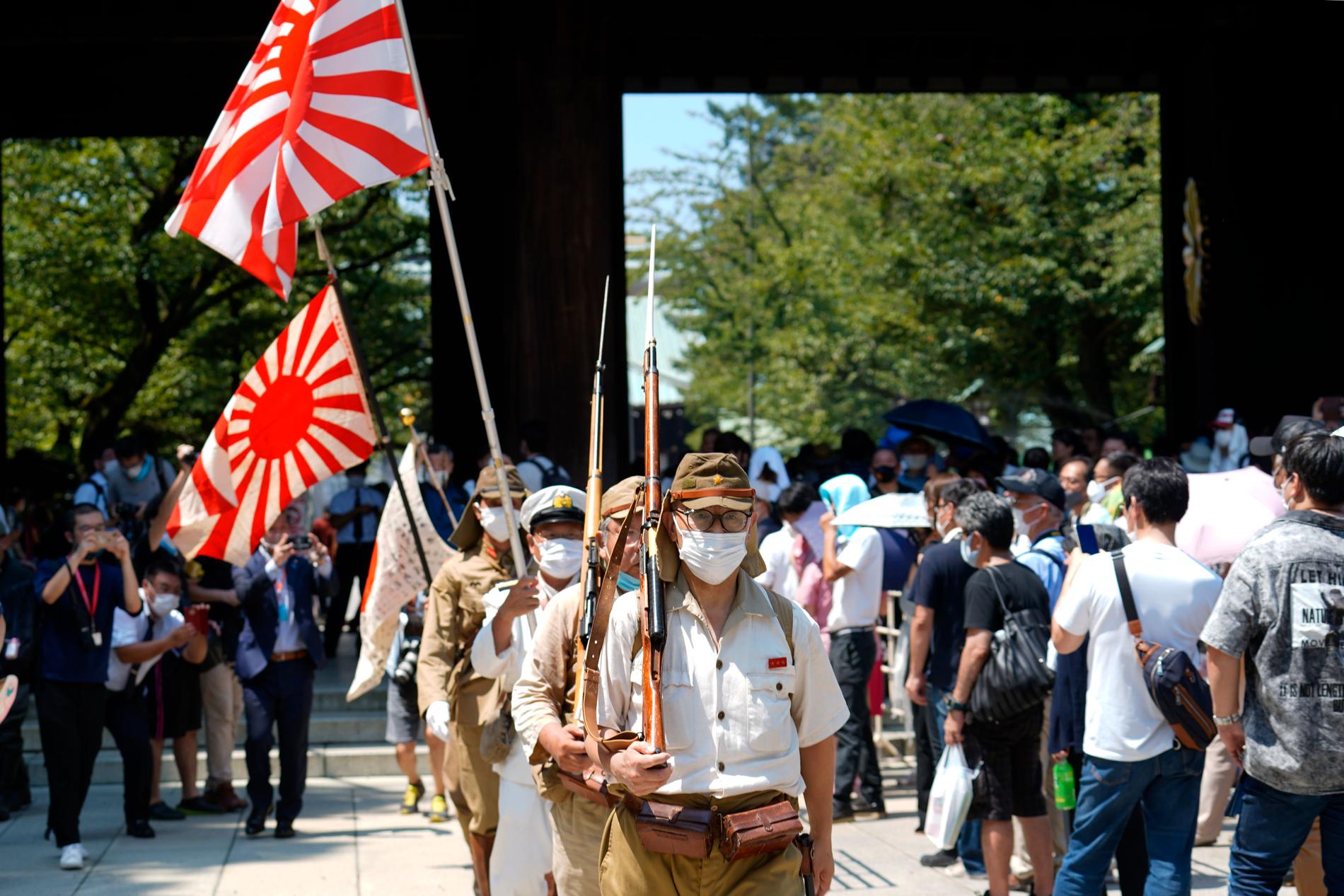 Under 75-årsdagen bar besökare vid shintohelgedomen flaggor från den kejserliga japanska armén, som upplöstes efter krigsslutet.
