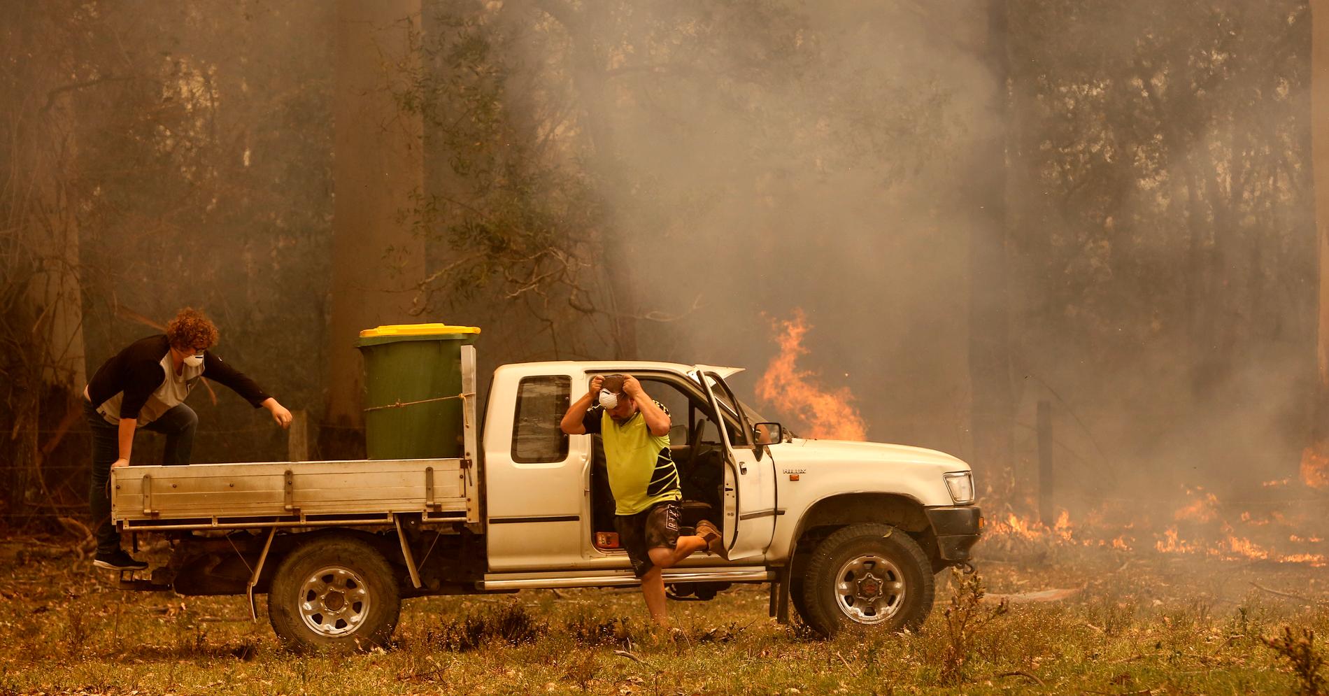 Två personer förbereder sig för att stoppa en brand i Koorainghat nära Taree i New South Wales på tisdagen.
