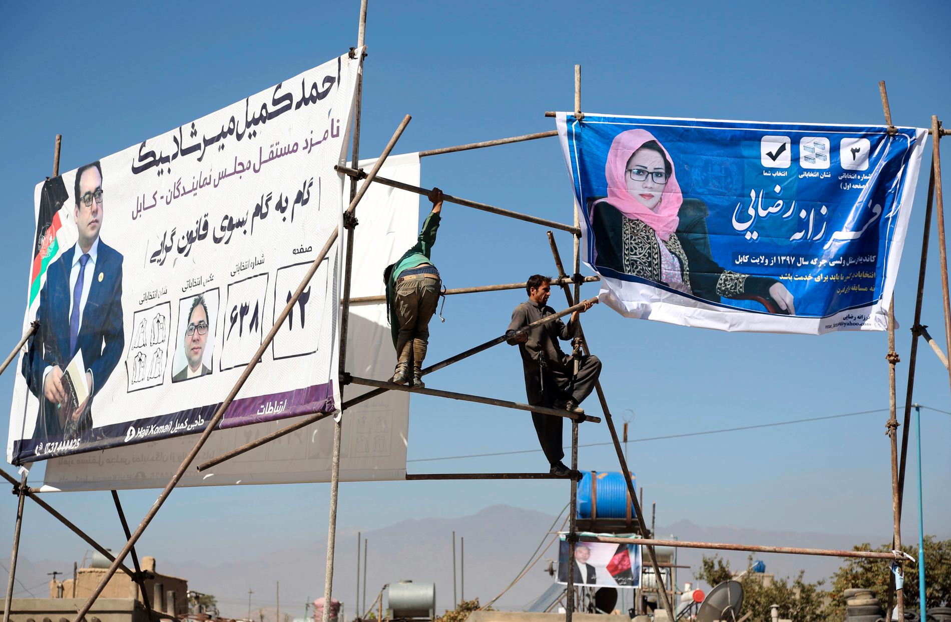 Valreklam sätts upp på en ställning i Kabul för kandidater till Afghanistans parlamentsval på lördag.