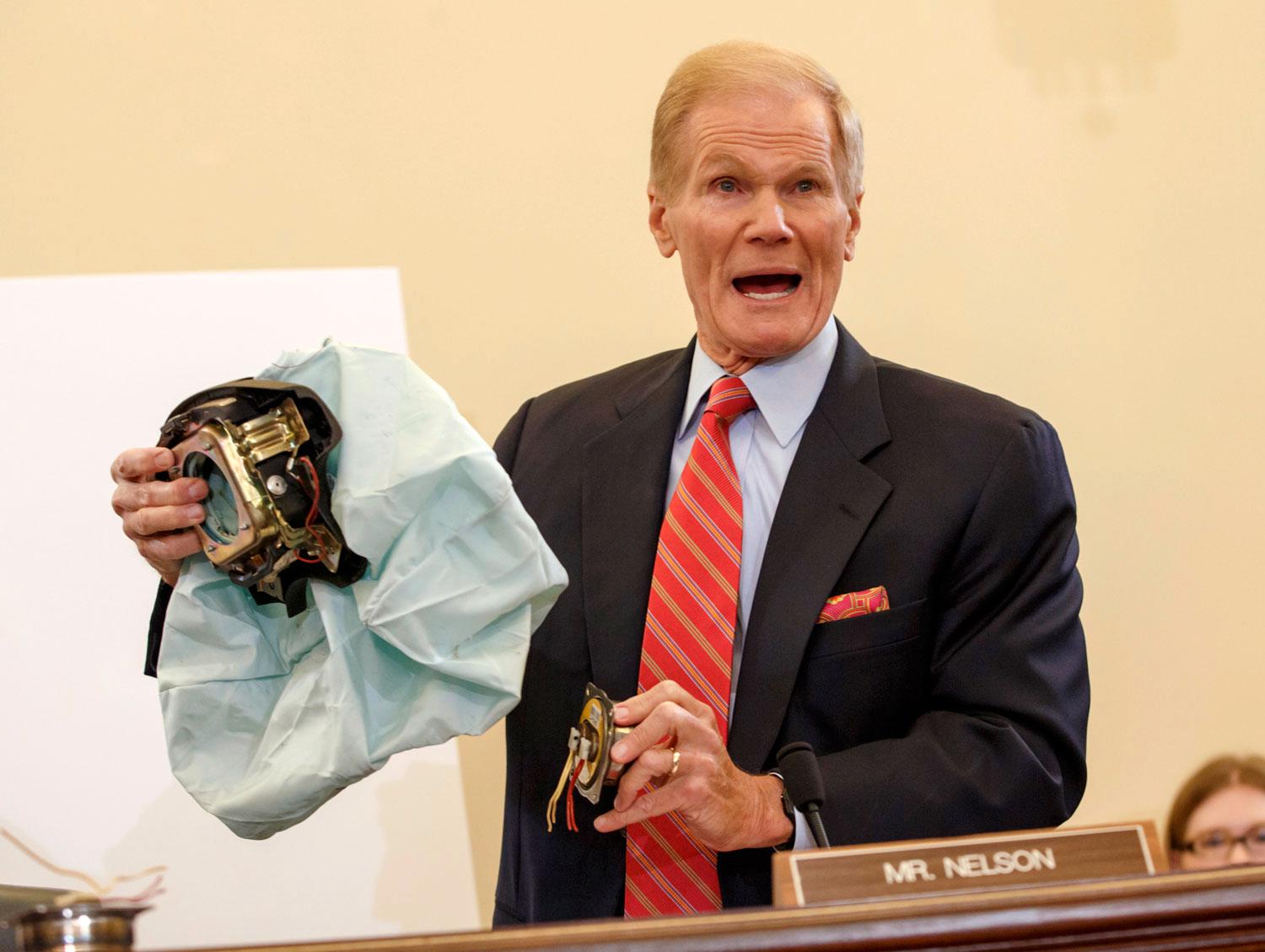 Floridas senator BIll Nelson håller upp en defekt Takata-krockkudde