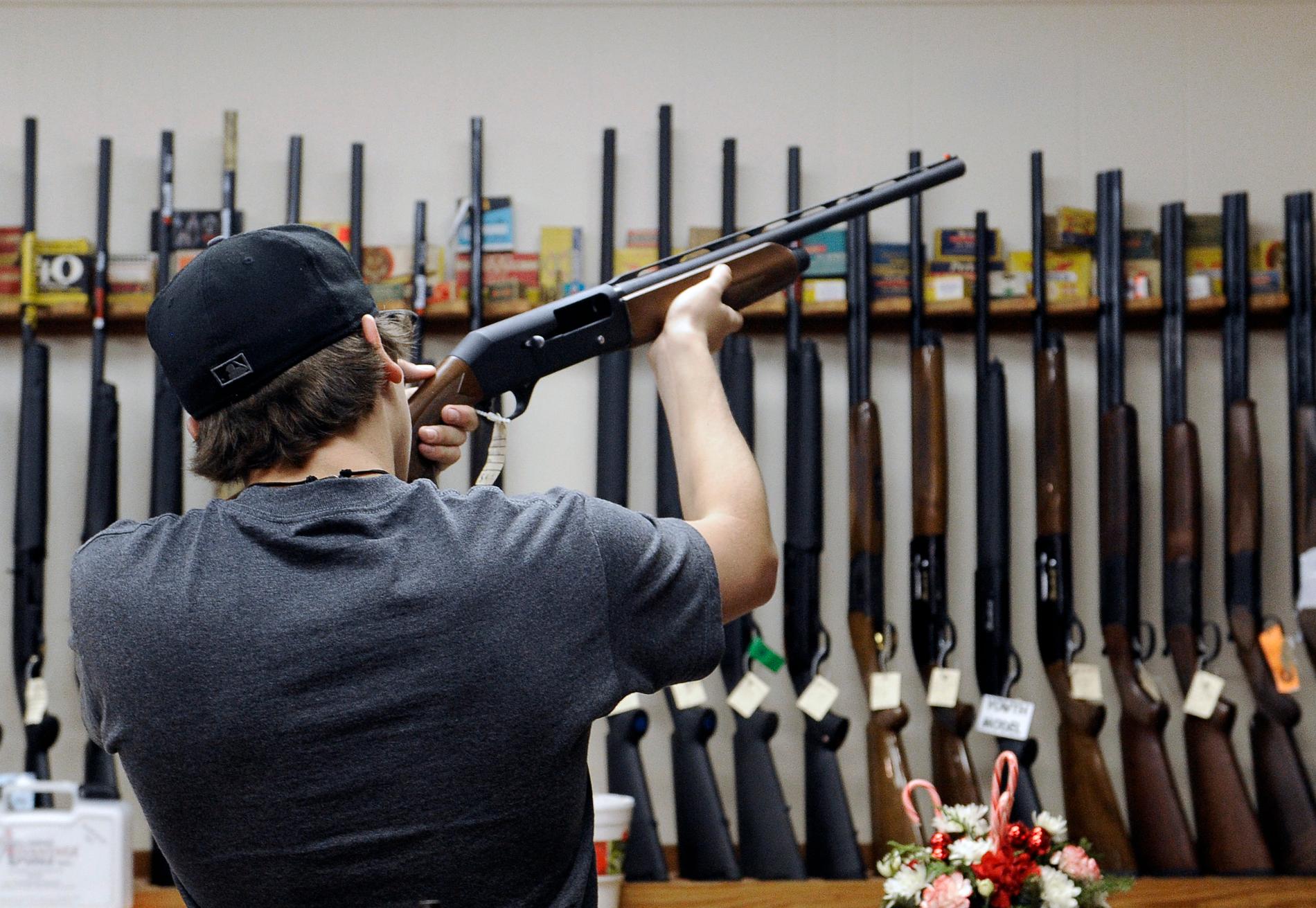 En man känner på ett hagelgevär i en vapenbutik i Texas. Arkivbild.