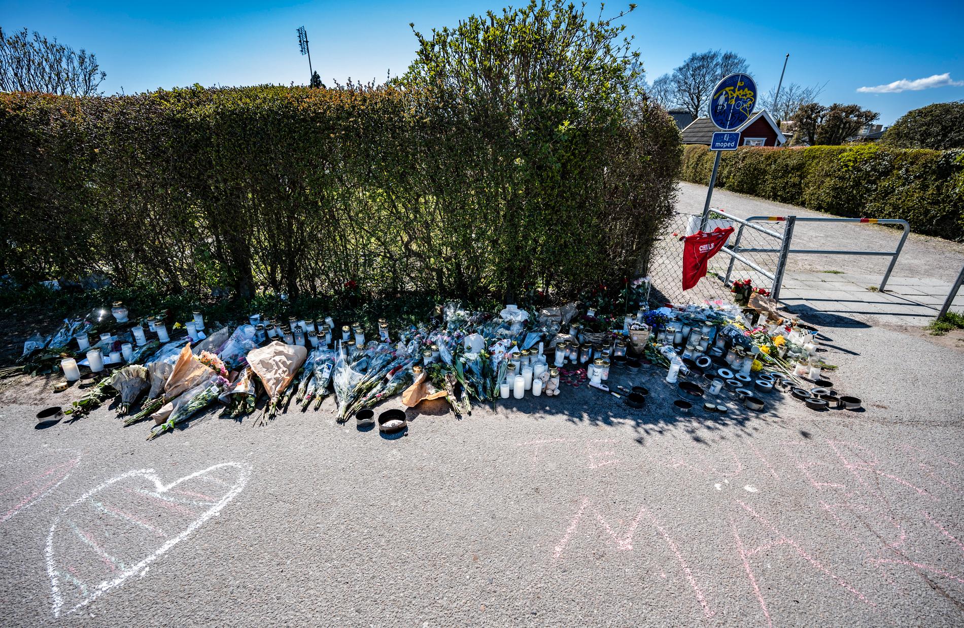 Blommor, ljus och meddelanden på en gång- och cykelbana i Malmö efter mordet på en 18-åring, som hittades skjuten i ett koloniområde. Arkivbild.