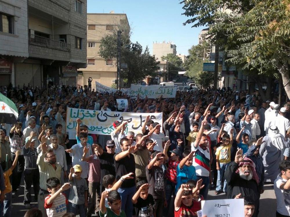 Demonstranter mot Bashar al-Assads regim vid en begravning för en man som dödats av regeringsstyrkot utanför Damaskus.