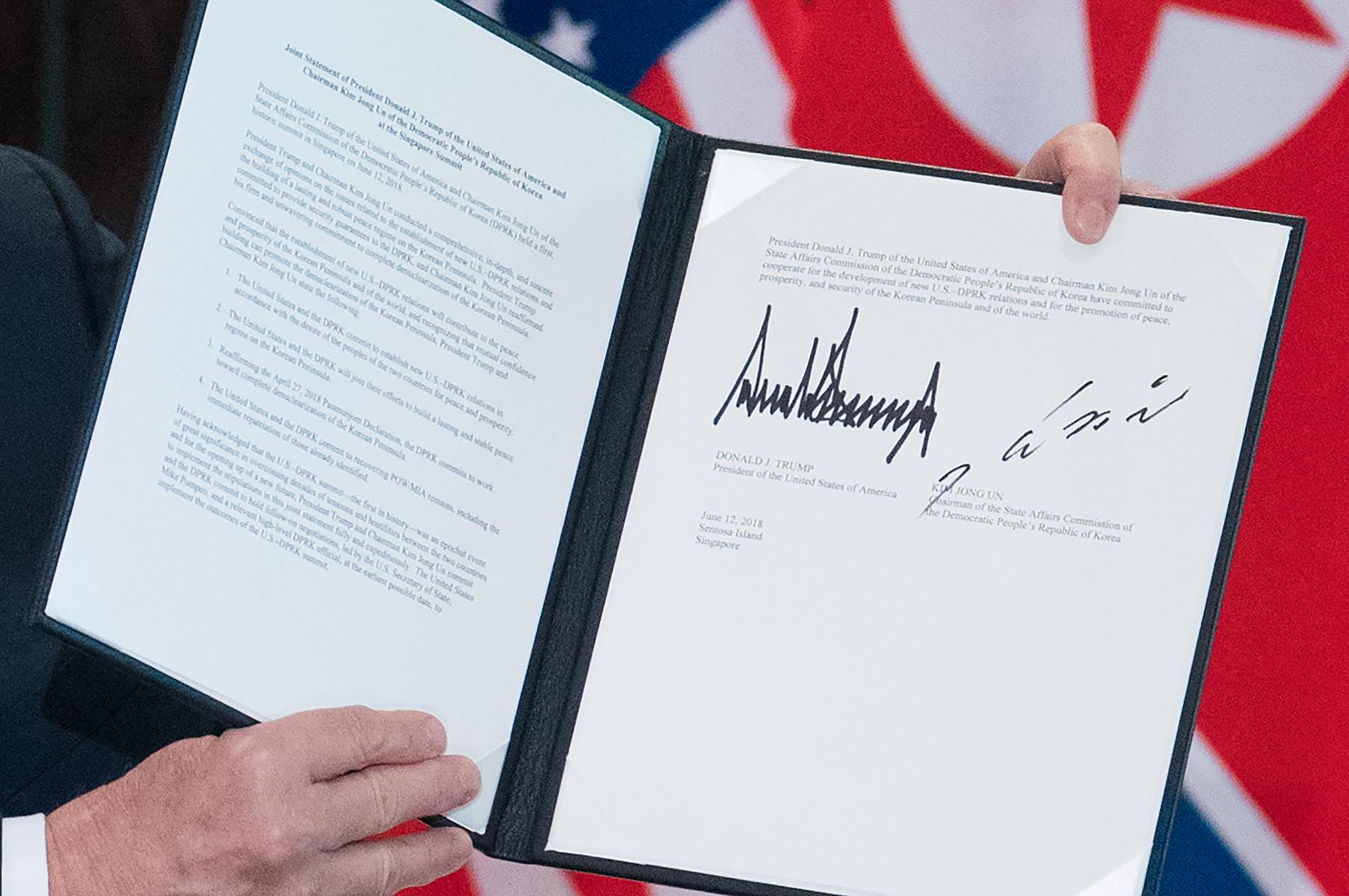 USA:s president Donald Trump håller upp dokumentet som han och Nordkoreas ledare Kim Jong-Un skrivit under i Singapore.