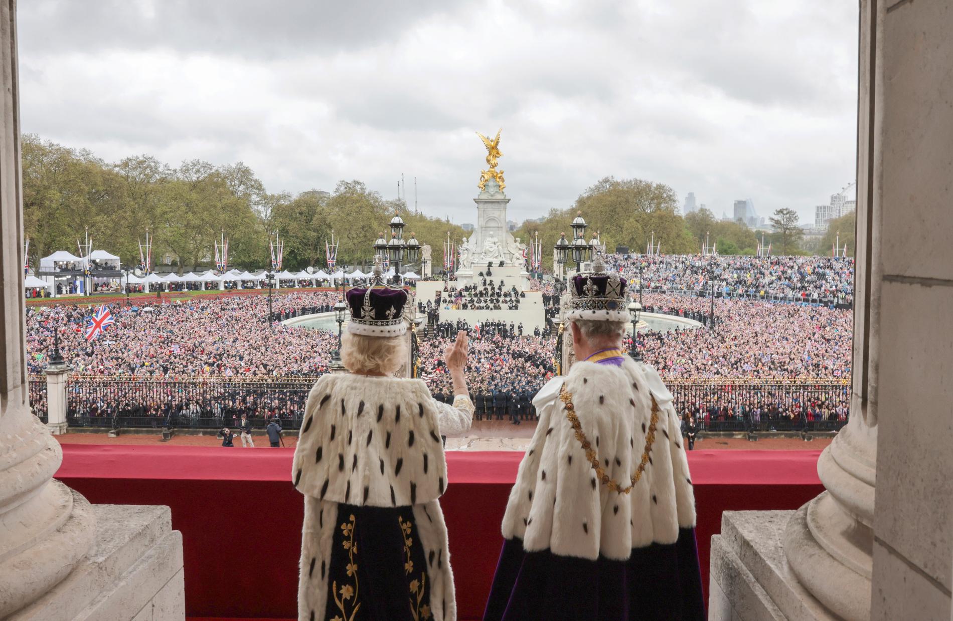 Det nykrönta kungaparet vinkar till folket från balkongen på Buckingham Palace. 