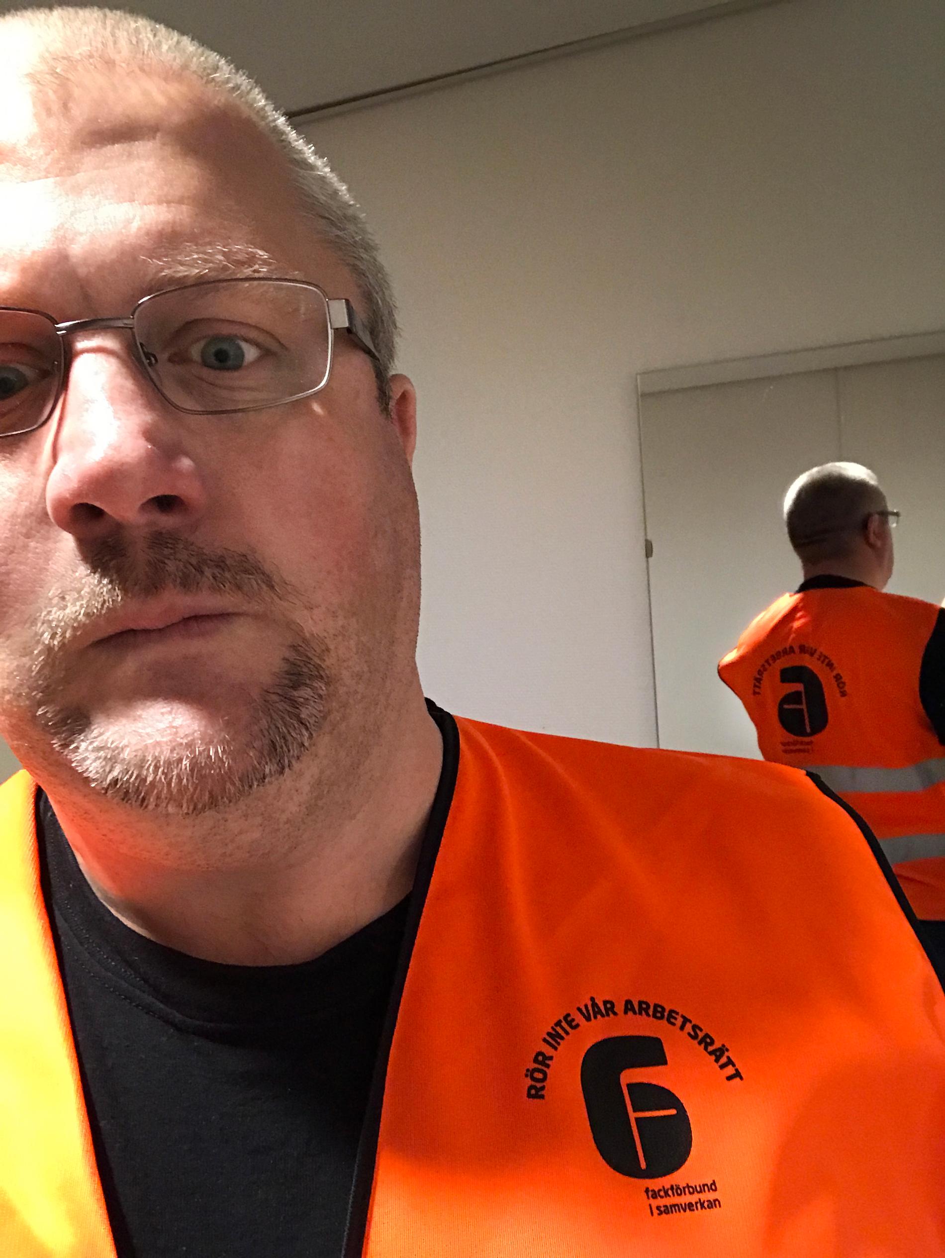 Sven Höckert i den orangea västen märkt ”Rör inte vår arbetsrätt”. 