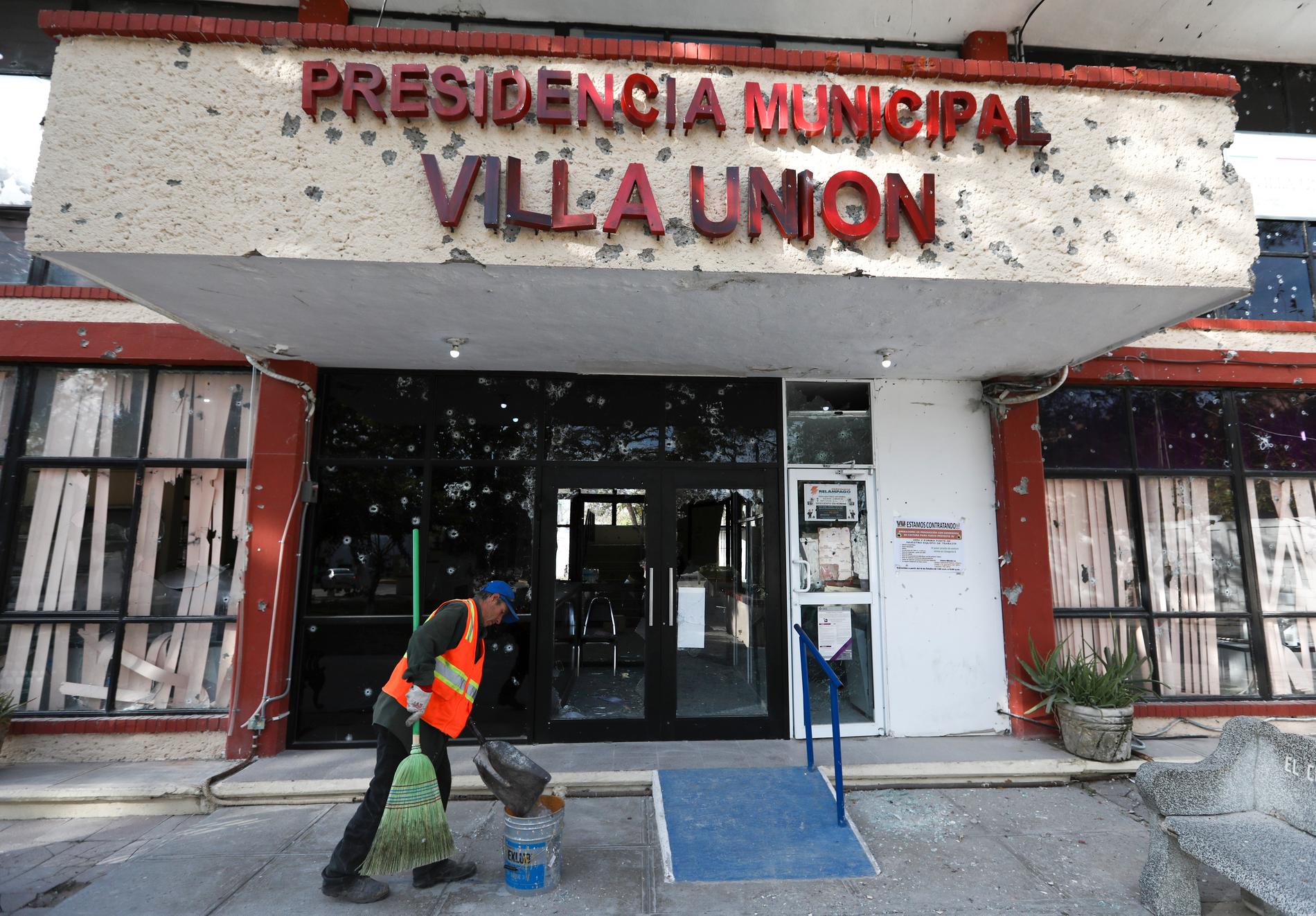 Mexiko är hårt drabbat av gängkriminalitet. Här städar en anställd upp utanför stadshuset i Villa Unión efter det att 23 människor dödats i staden i strider mellan säkerhetsstyrkor och en kraftigt beväpnad drogkartell i december.