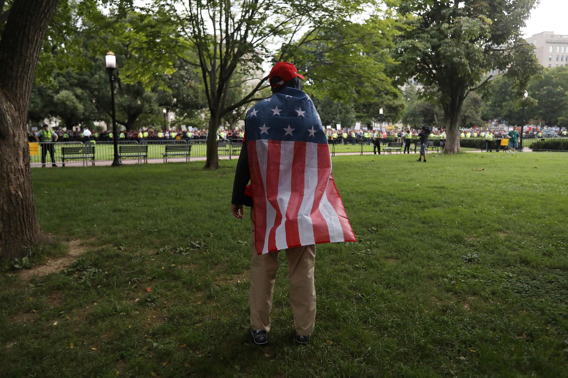 En demonstrant från Alt-right bär en amerikansk flagga vid demonstrationen i Washington.