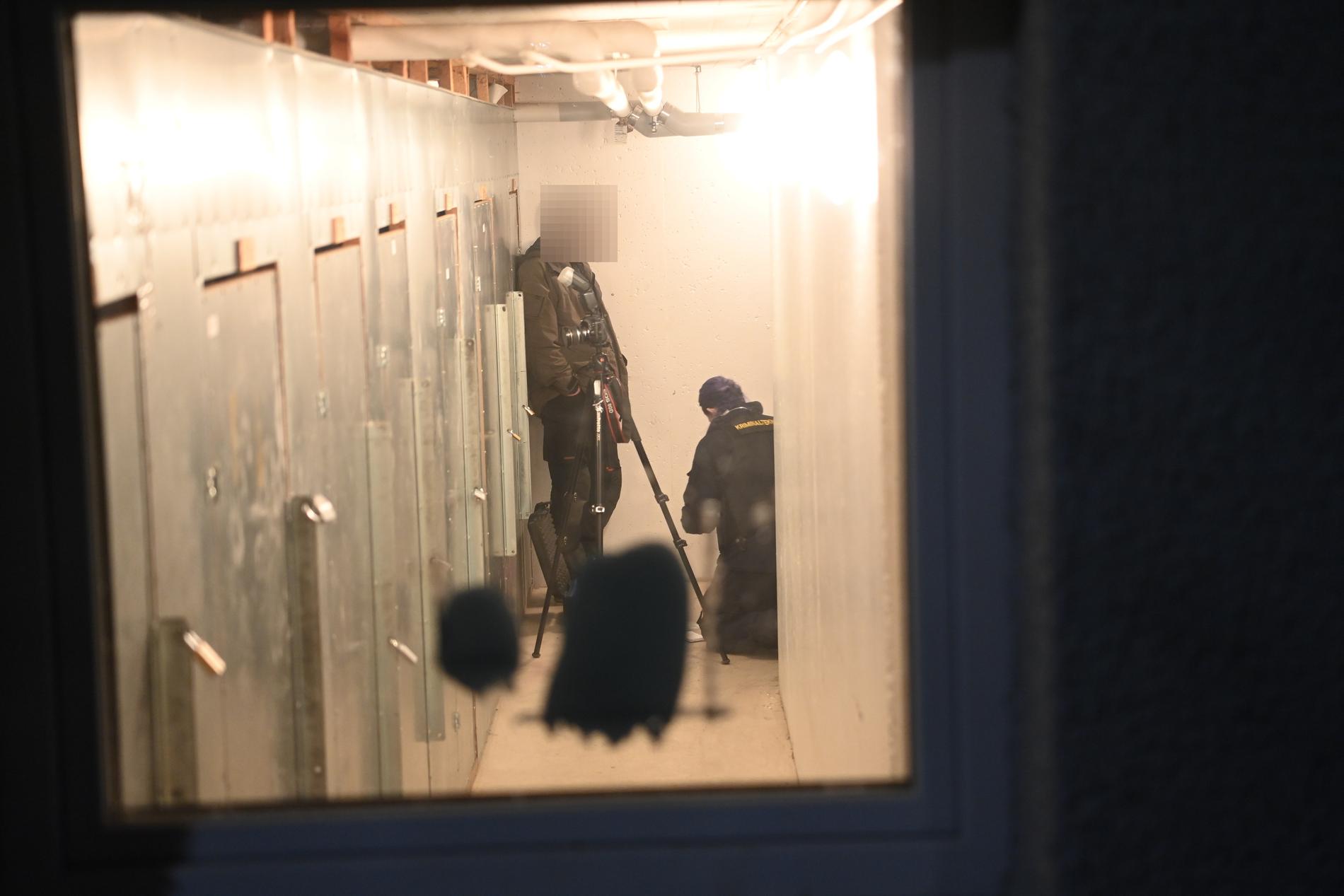 Polisens tekniker undersöker ett källarförråd i huset i Skogås mycket noga. Det är i nuläget oklart vad man misstänker ska ha hänt i källaren. 