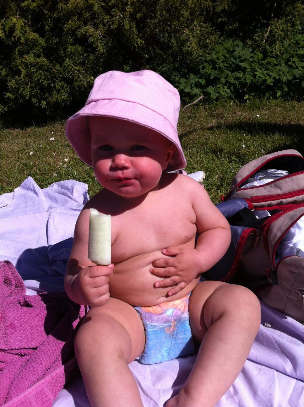 Mamma Anna tolkar klappen på magen som att den här lilla tjejen gillar sin piggelin. Sommar vid badet i Svedala.