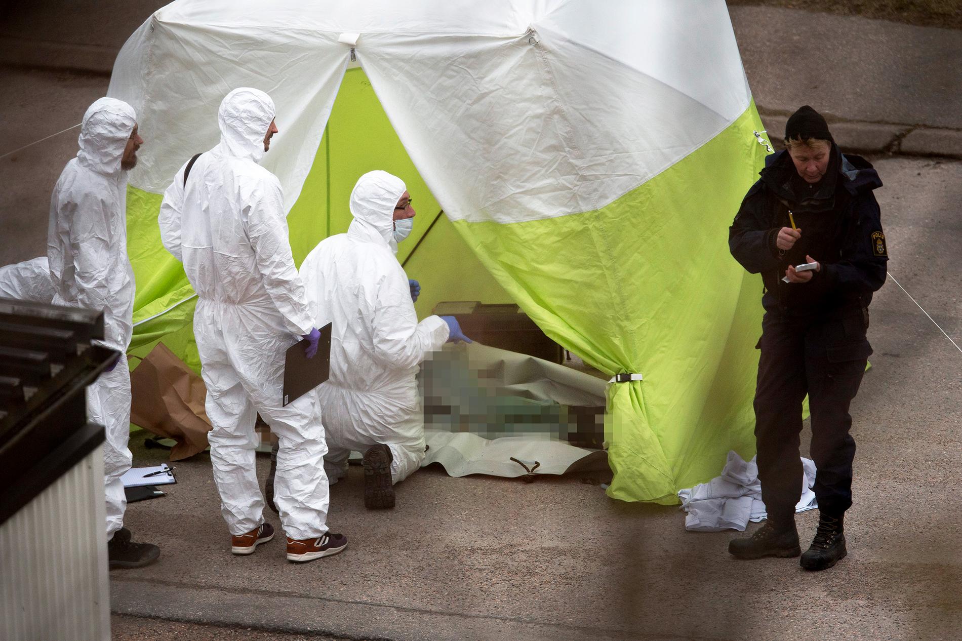 Polisens tekniker arbetar på platsen i närheten av Uddevalla sjukhus där tre mördade personer hittades på lördagsmorgonen.