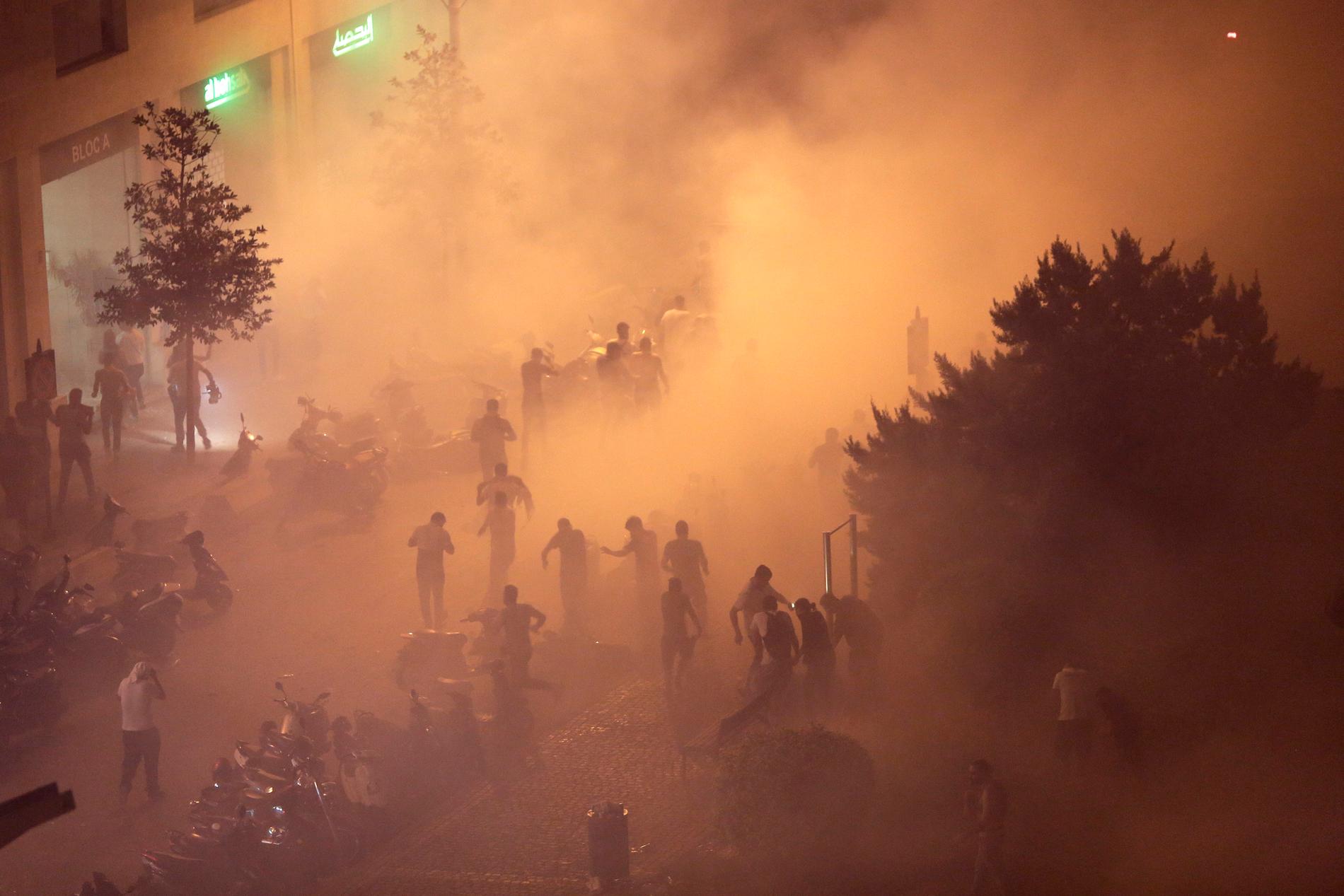Kravallpolis sprutar tårgas under demonstrationerna.