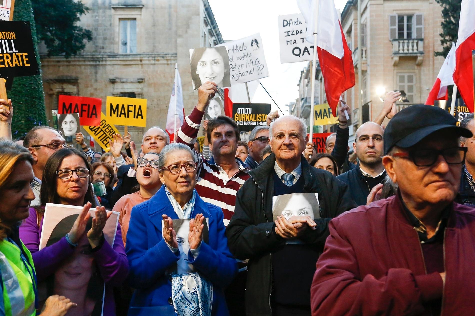 Rose och Michael Vella, paret i mitten, bär med sig porträtt av sin mördade dotter, den grävande journalisten Daphne Caruana Galizia, vid demonstrationen.