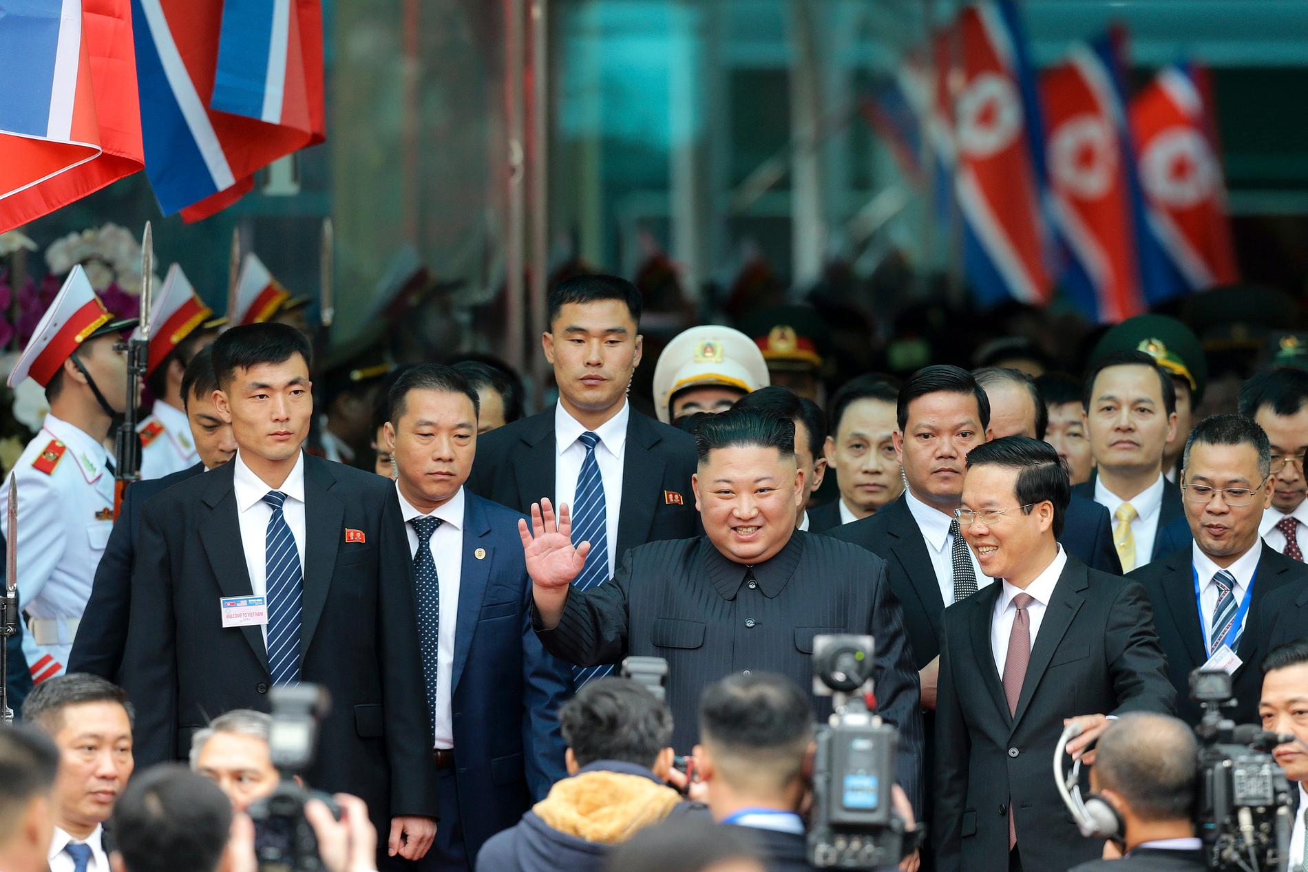 Kim Jong-Un vinkar till pressuppbådet efter ankomsten.