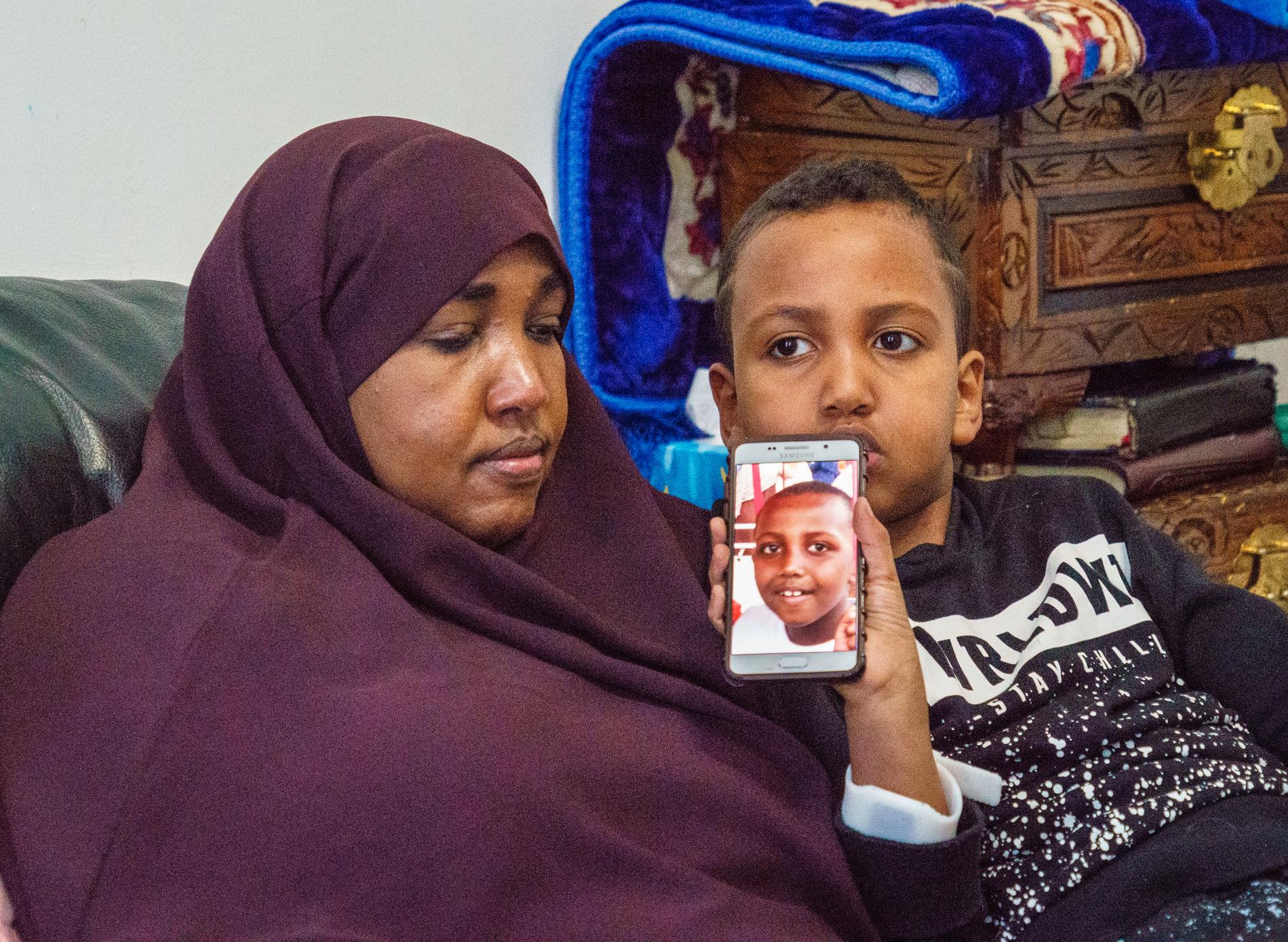 Ahmad, tätt intill mamma Deega, visar upp bilden på sin döde bror Yuusuf.