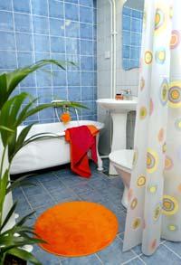 SKÖN STÄMNING. Inbyggd golv­värme, Medelhavsblått kakel och badkar på ben förhöjer stämningen i badrummet.  