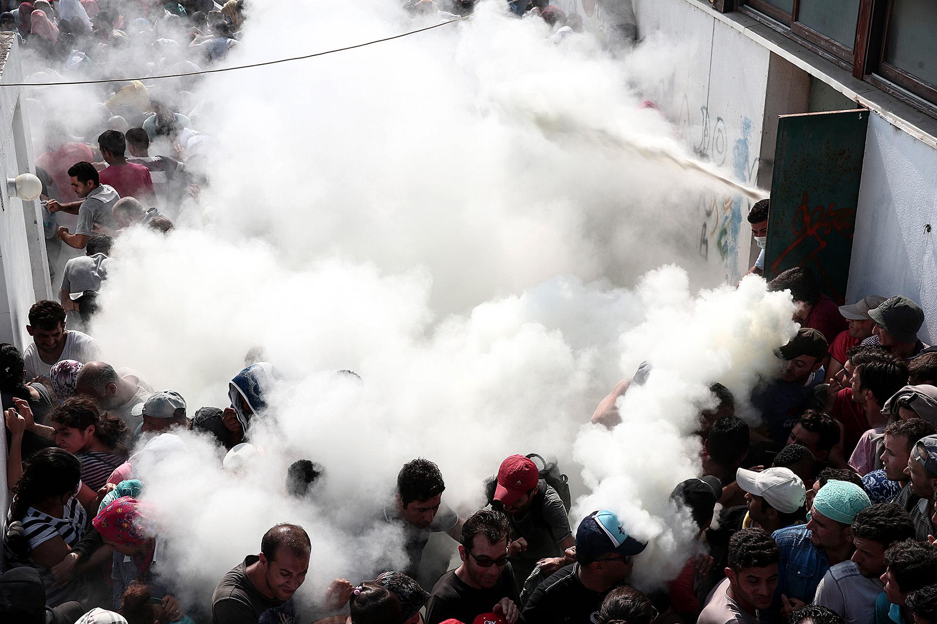 Polisen sprutar med  brandsläckare mot flyktingar på fotbollsstadium på kos, Grekland.