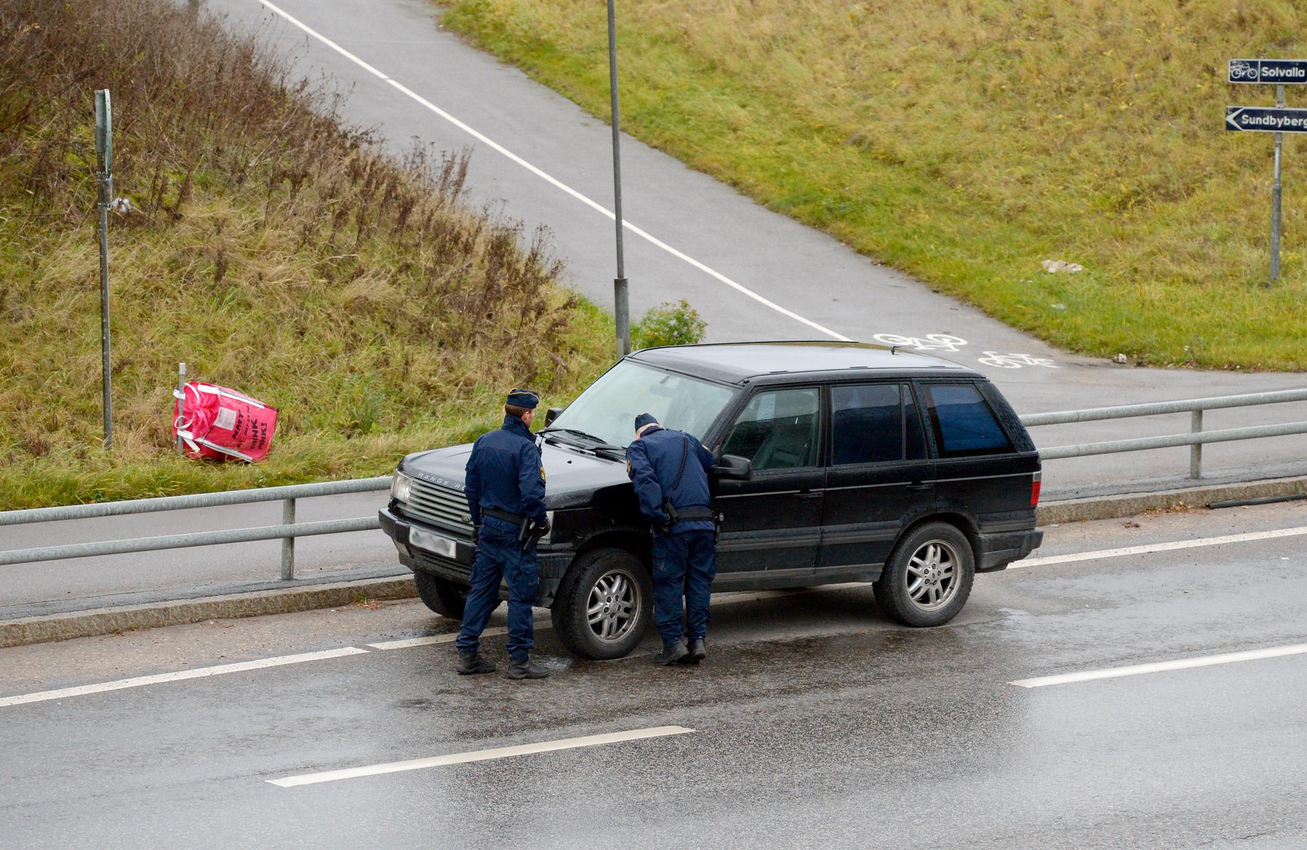 En misstänkt bil, en mörk Range Rover med utländska skyltar, står parkerad alldeles intill staketet.
