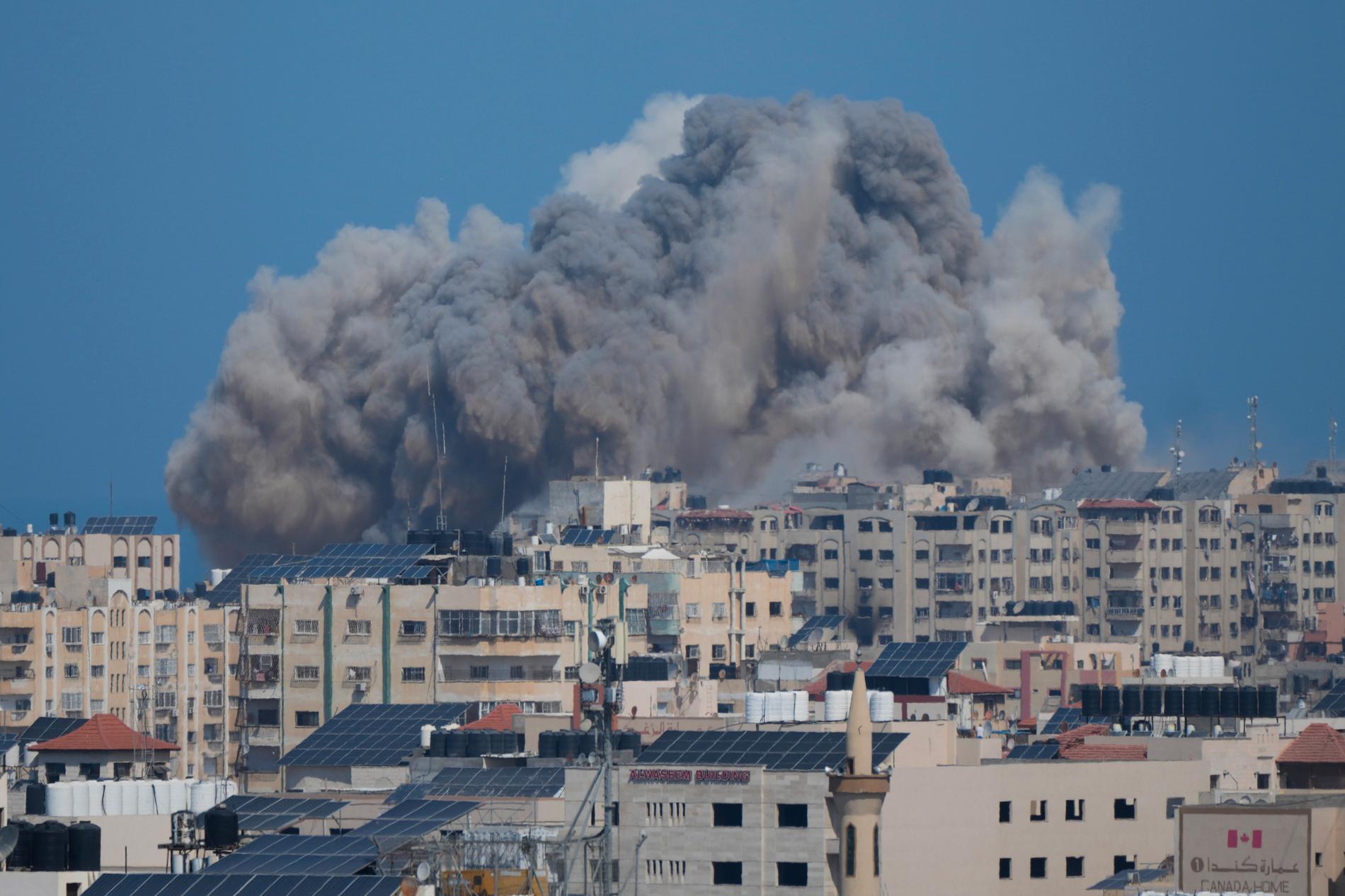 Rök stiger från byggnader i Gaza. 
