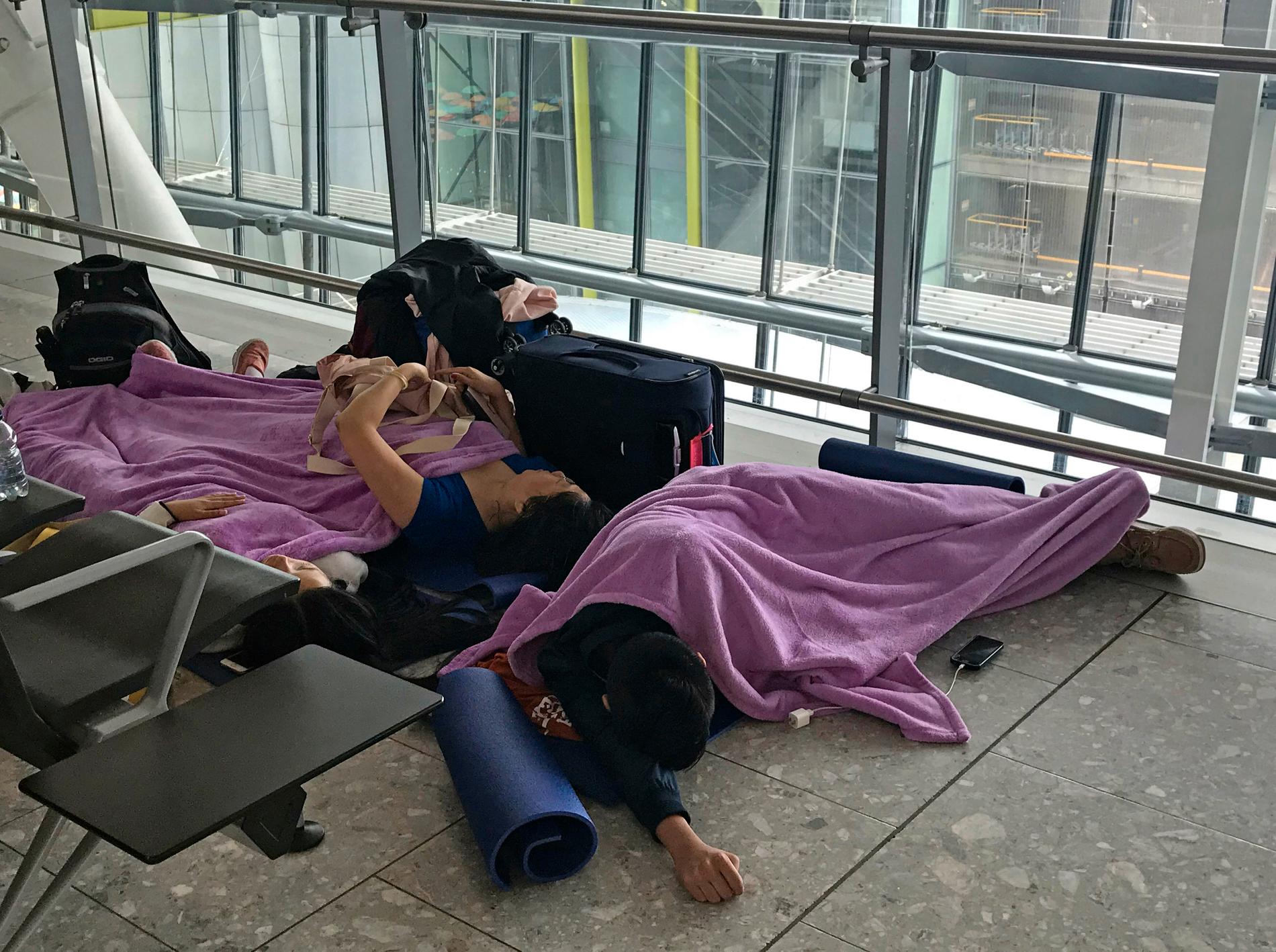 Resenärer som vilar på golvet på terminal 5 på flygplatsen Heathrow efter att ett oväder orsakat stora förseningar i flygtrafiken.