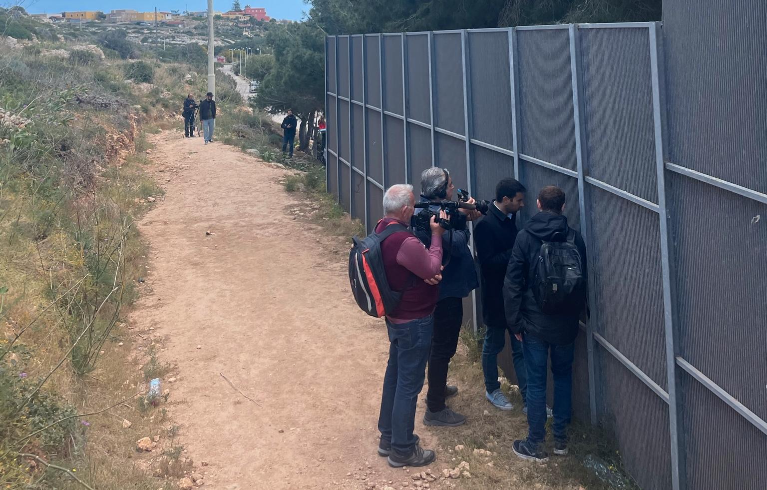 Utanför flyktingförläggningen samlas journalisterna.