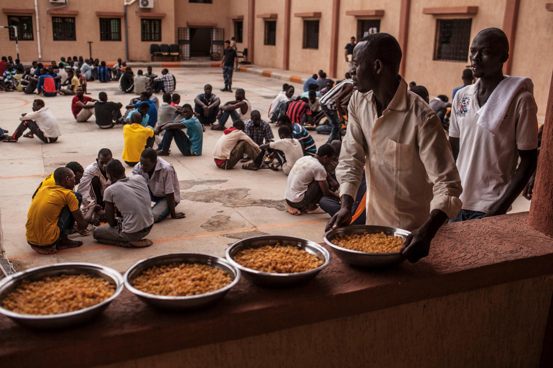 Arkivbild. En migrant håller en skål med pasta under en lunch i ett flyktingförvar i Libyen.