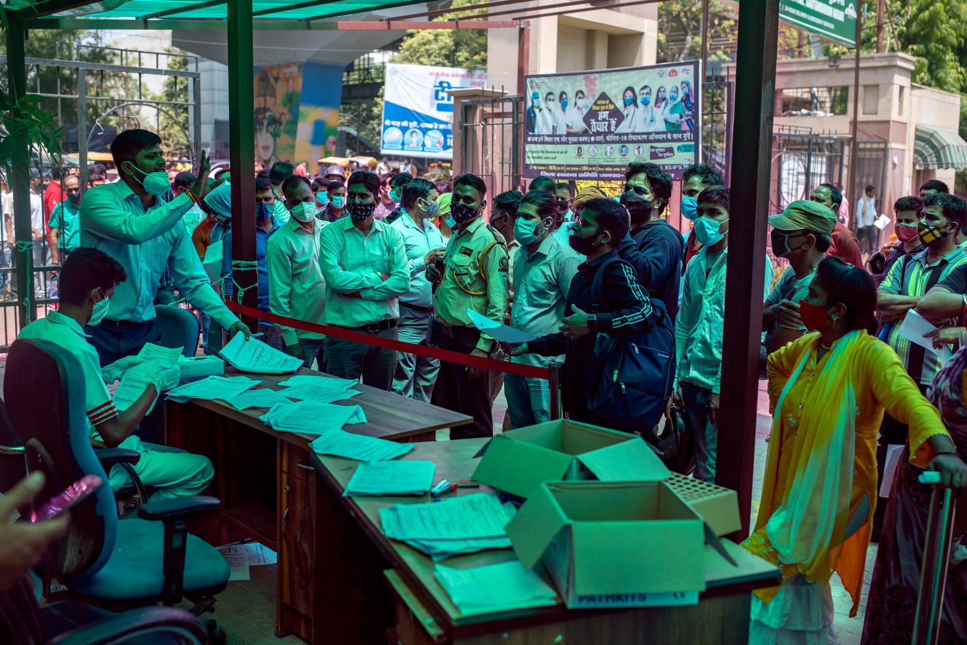 En otålig folkmassa – där få håller avstånd – väntar på att registrera sig för att ta covidprov på ett sjukhus utanför New Delhi i Indien.