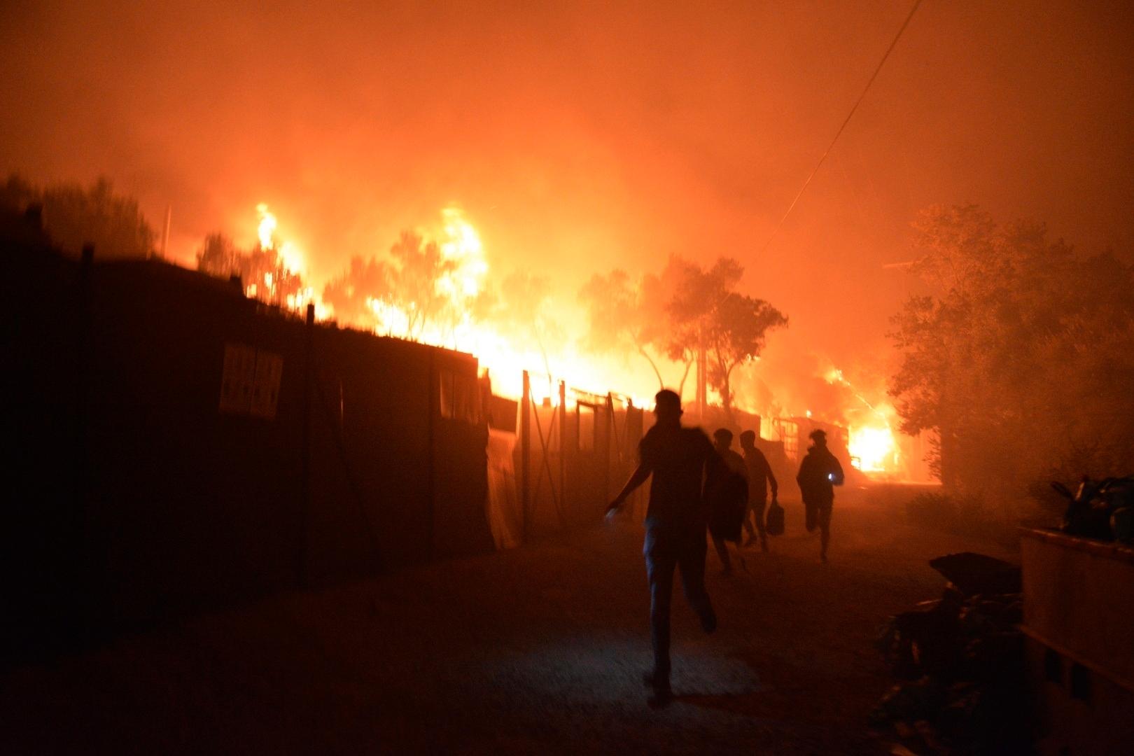 Migranter försöker komma undan elden vid flyktinglägret Moria, på Lesbos i Grekland.