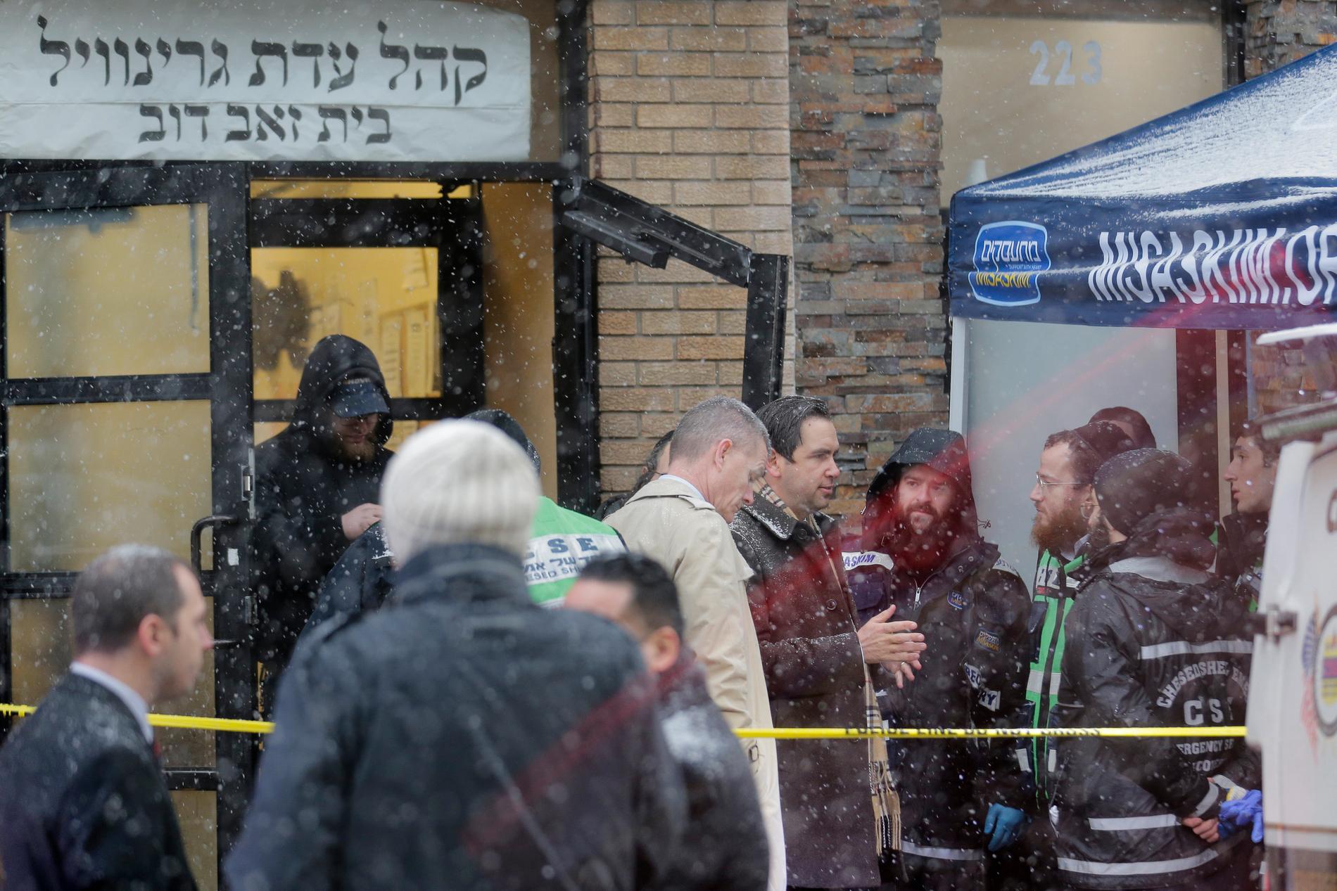 Jersey Citys borgmästare Steven Fulop, i mörk rock i mitten av bilden, utanför den judiska butiken. Fulop har gett polisen direktiv om att öka bevakningen i områden där många judar bor.