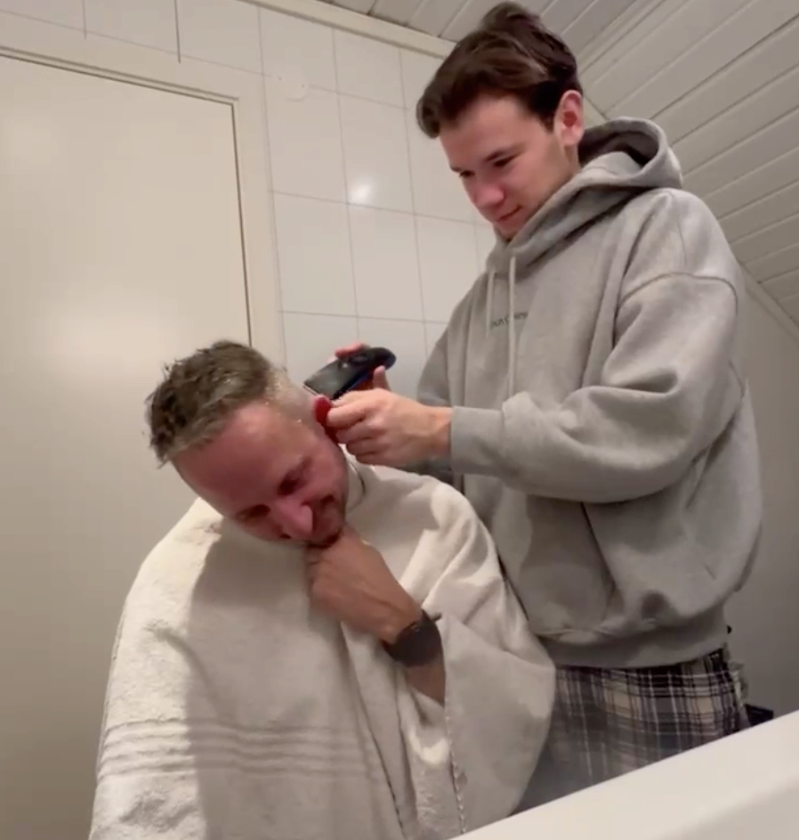Marcus Gunnarsen rakar av pappans hår efter vinsten i Melodifestivalen. 