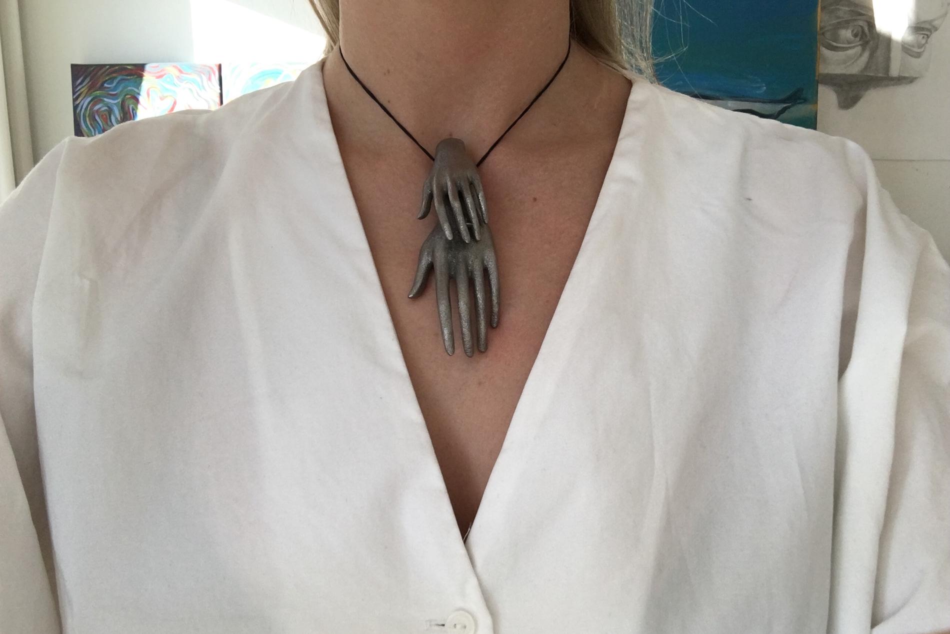 Det 3D-printade halsbandet som föreställer två händer.