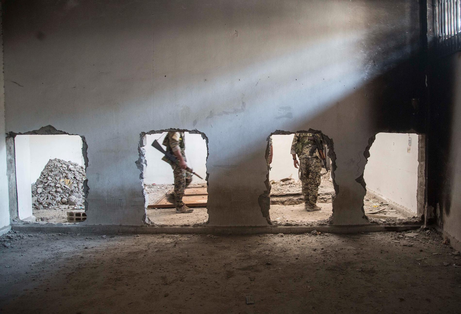Den kurdisk-arabiska milisen SDF söker igenom en byggnad som tidigare kontrollerats av terrorrörelsen IS. Arkivbild.