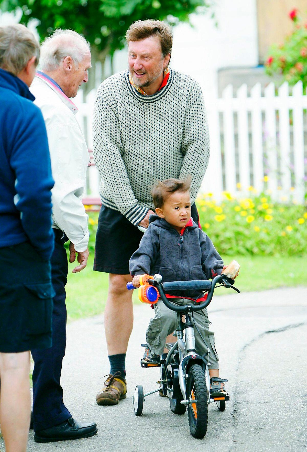 Leon testar asfalten på Åstol med cykeln, medan Janne ”tjôtar” lite med grannarna.
