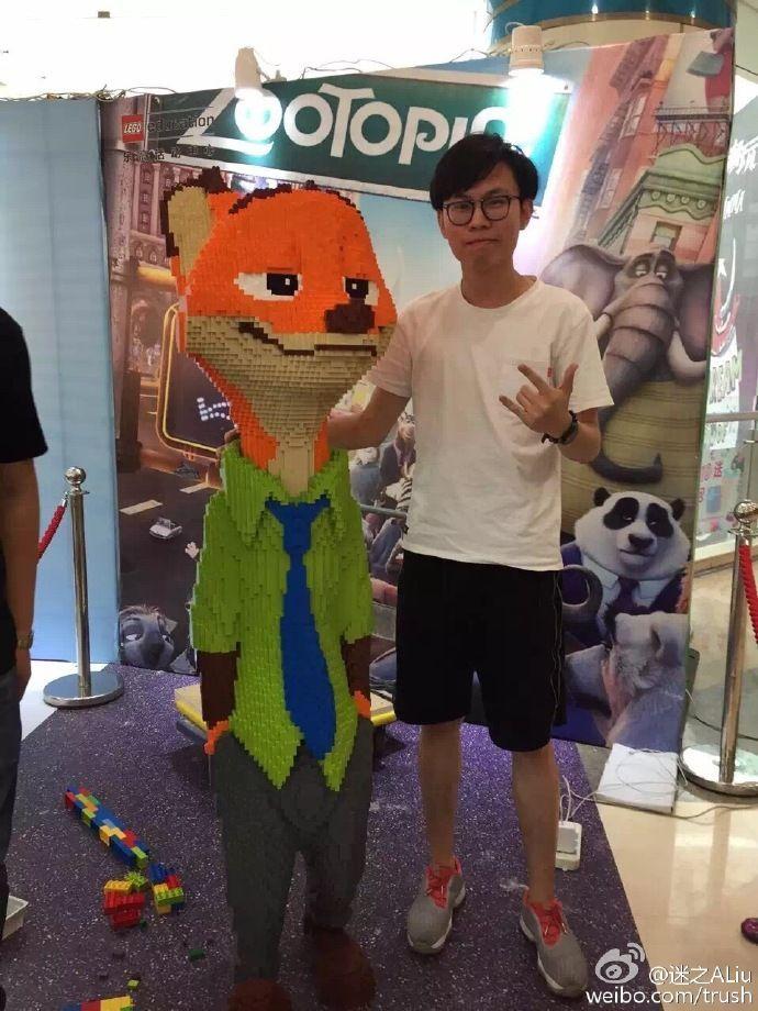 Konstnären Zhao tillsammans med statyn av figuren Nick Wilde från Disneyfilmen Zootopia.
