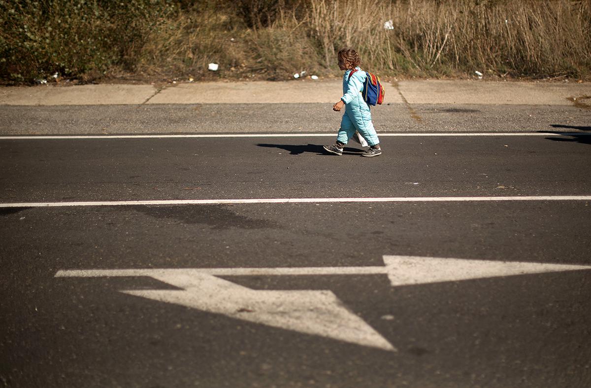 Ungern, Hegyeshalom: En ung flicka går ensam efter de hundratals flyktingar som tagit sig med tåg till Hegyeshalom som ligger nära gränsen mot Österrike. Promenaden från tågstationen till Österrikiska gränsen är fyra kilometer lång.