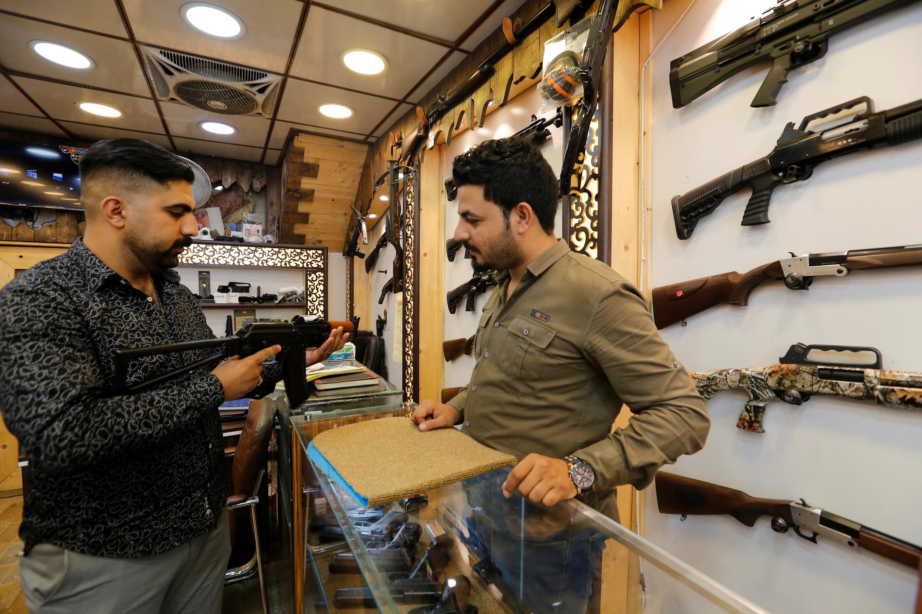 En köpare granskar ett vapen i en av Bagdads vapenbutiker.