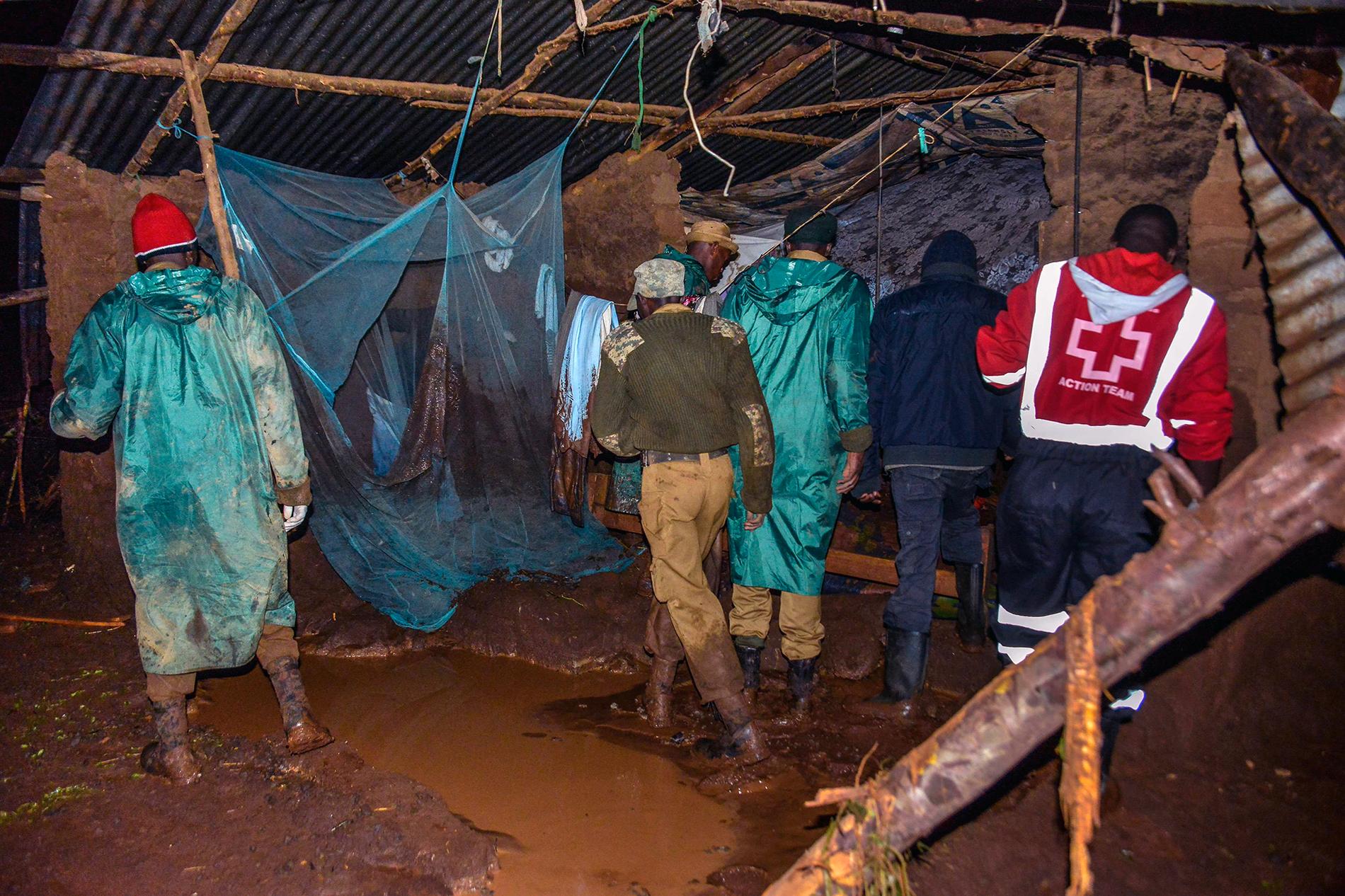 Räddningsarbetare söker igenom ett boende efter att en damm brustit i Nakaru provinsen i Kenya. 